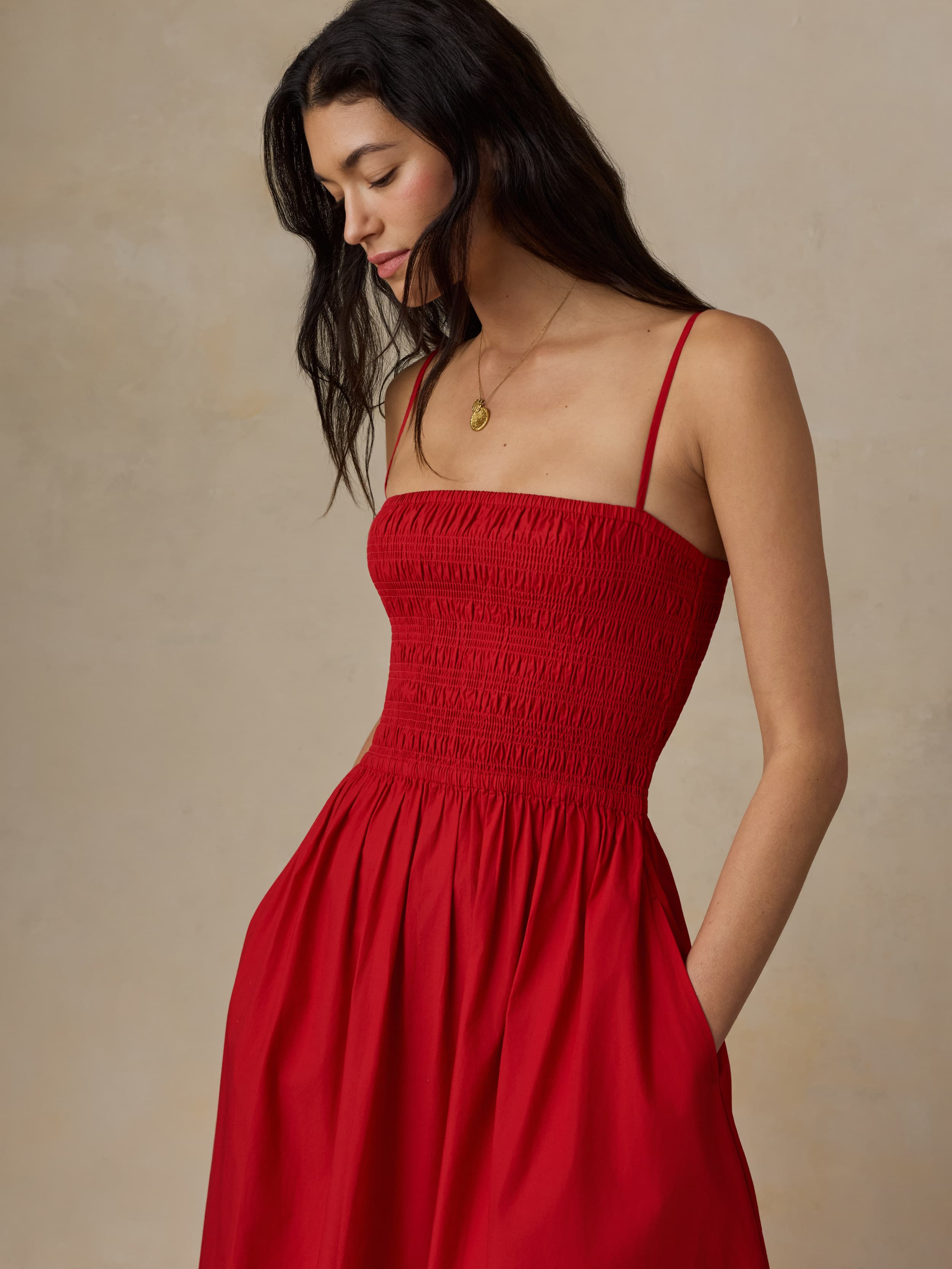 Woman wearing a red dress against a beige background