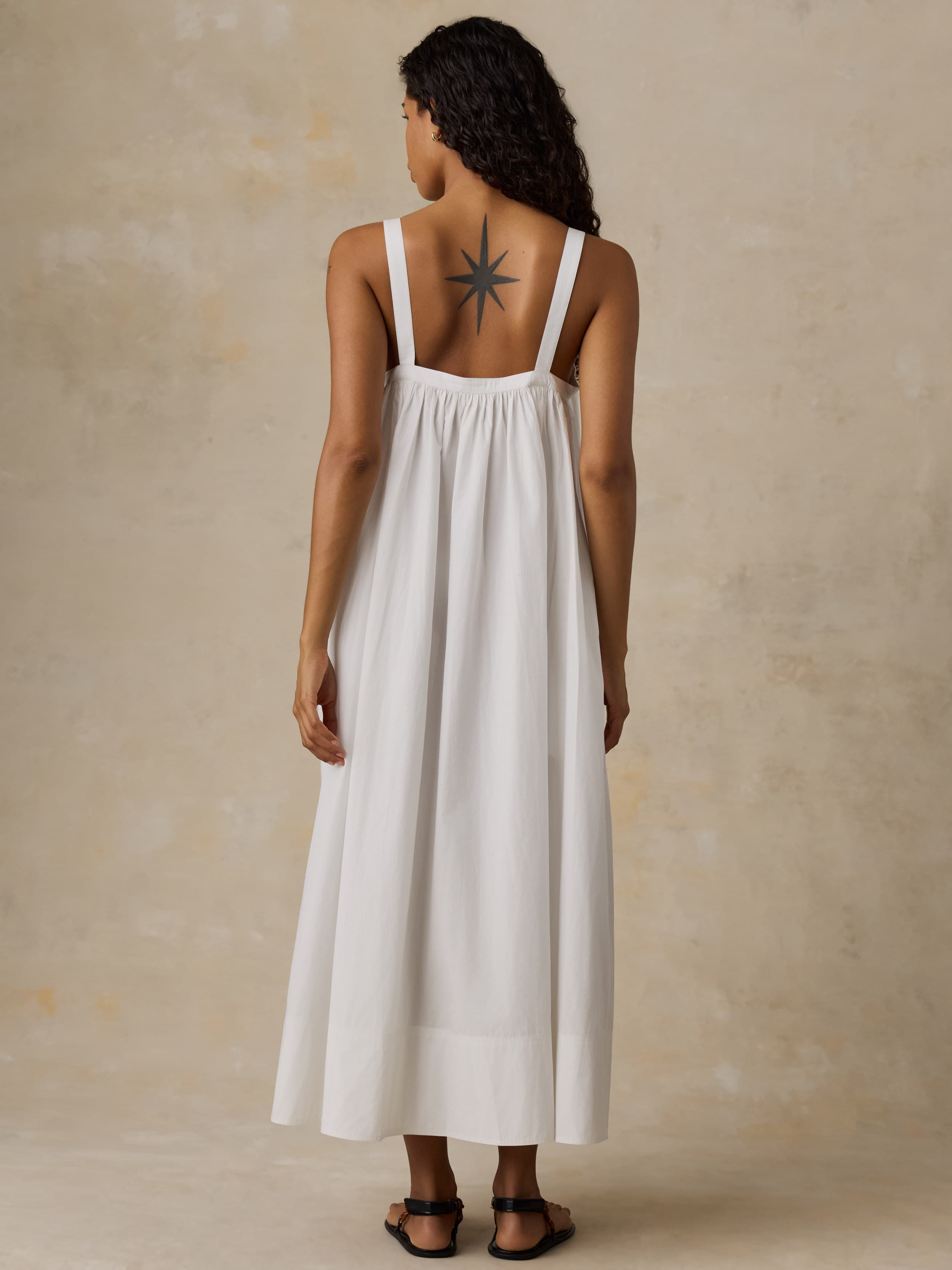 Woman wearing a white dress with a beige background