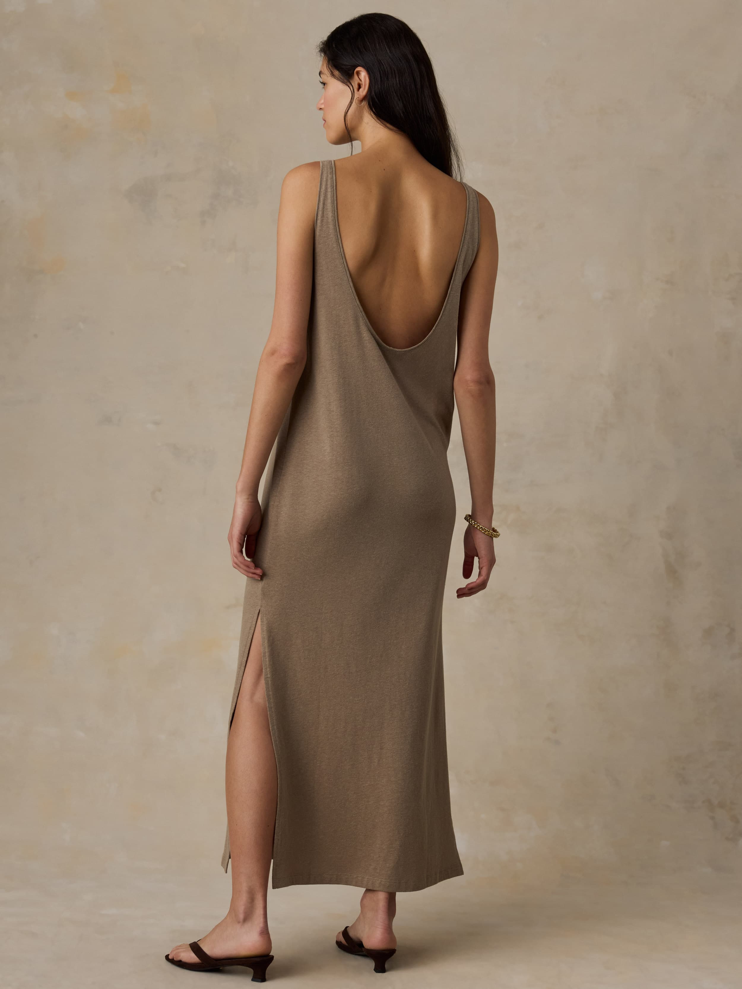 Woman wearing a long beige dress against a neutral background
