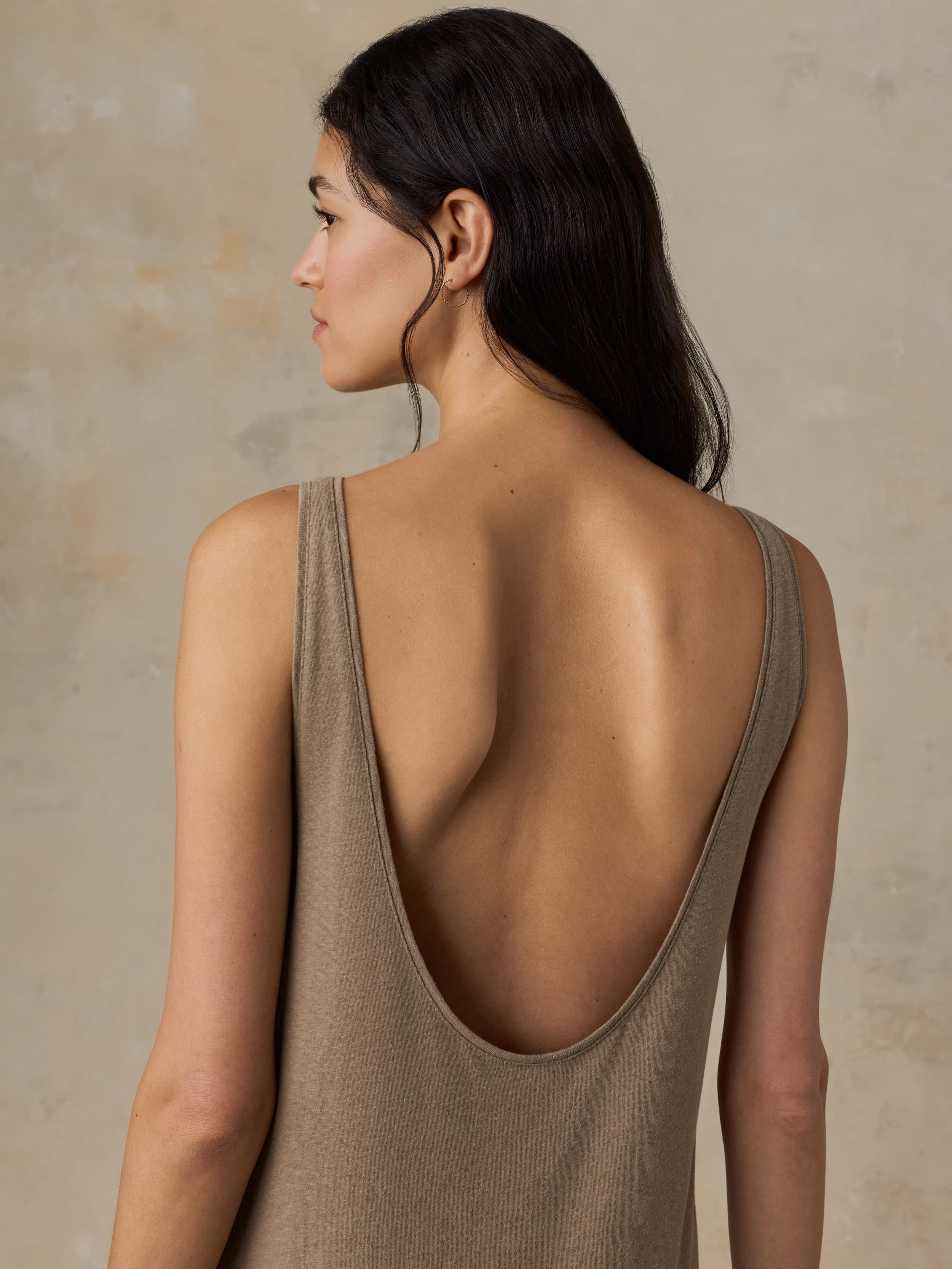 Woman wearing a long beige dress against a neutral background