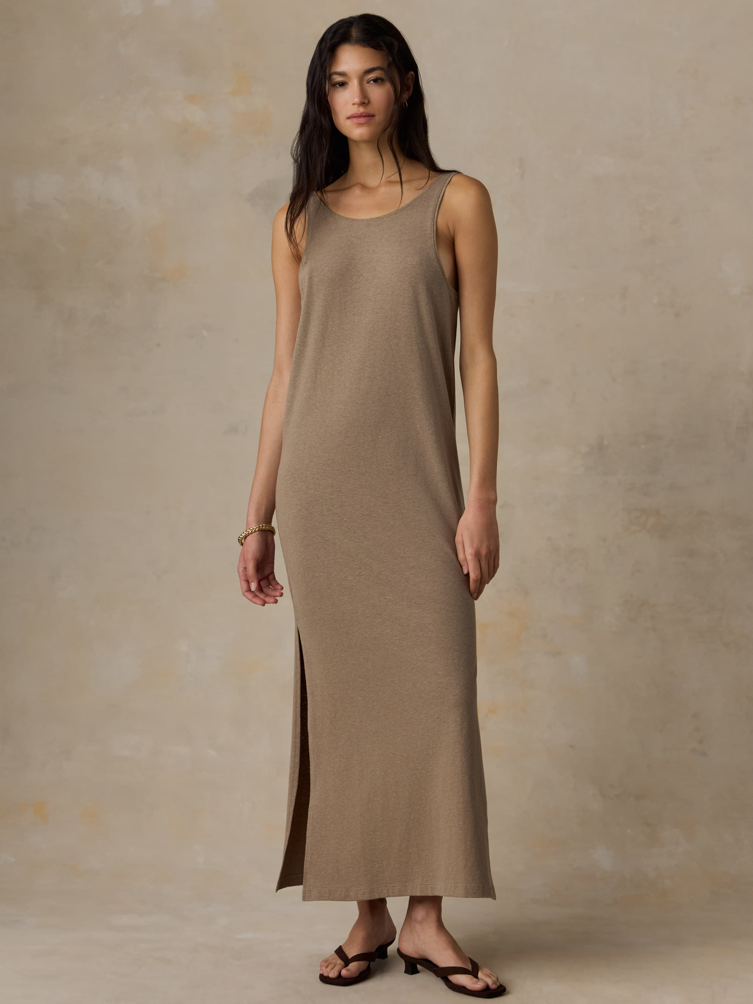 Woman wearing a long beige dress against a neutral background
