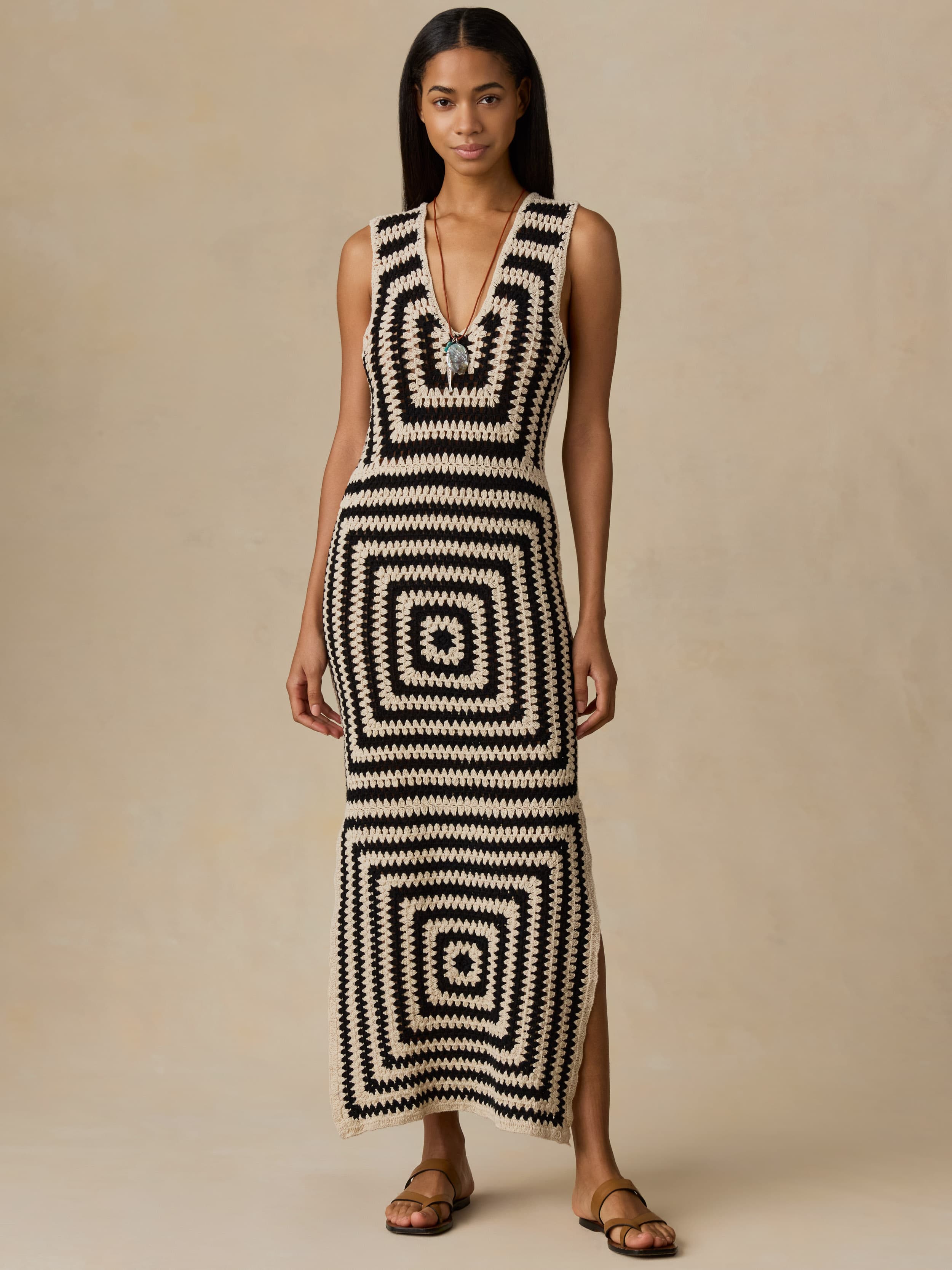 Woman wearing a black and white patterned dress against a beige background