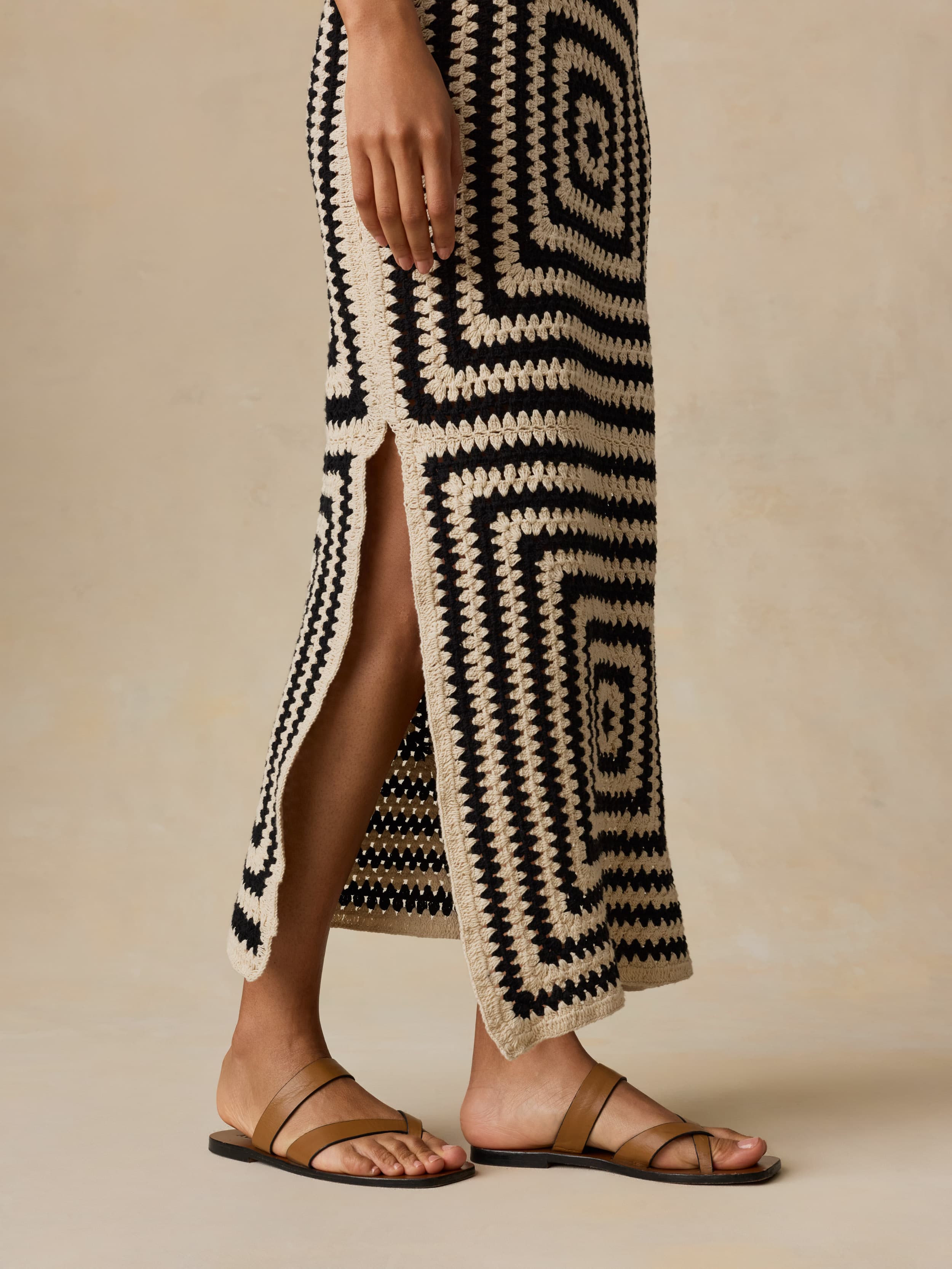 Woman wearing a long, patterned dress with a neutral background