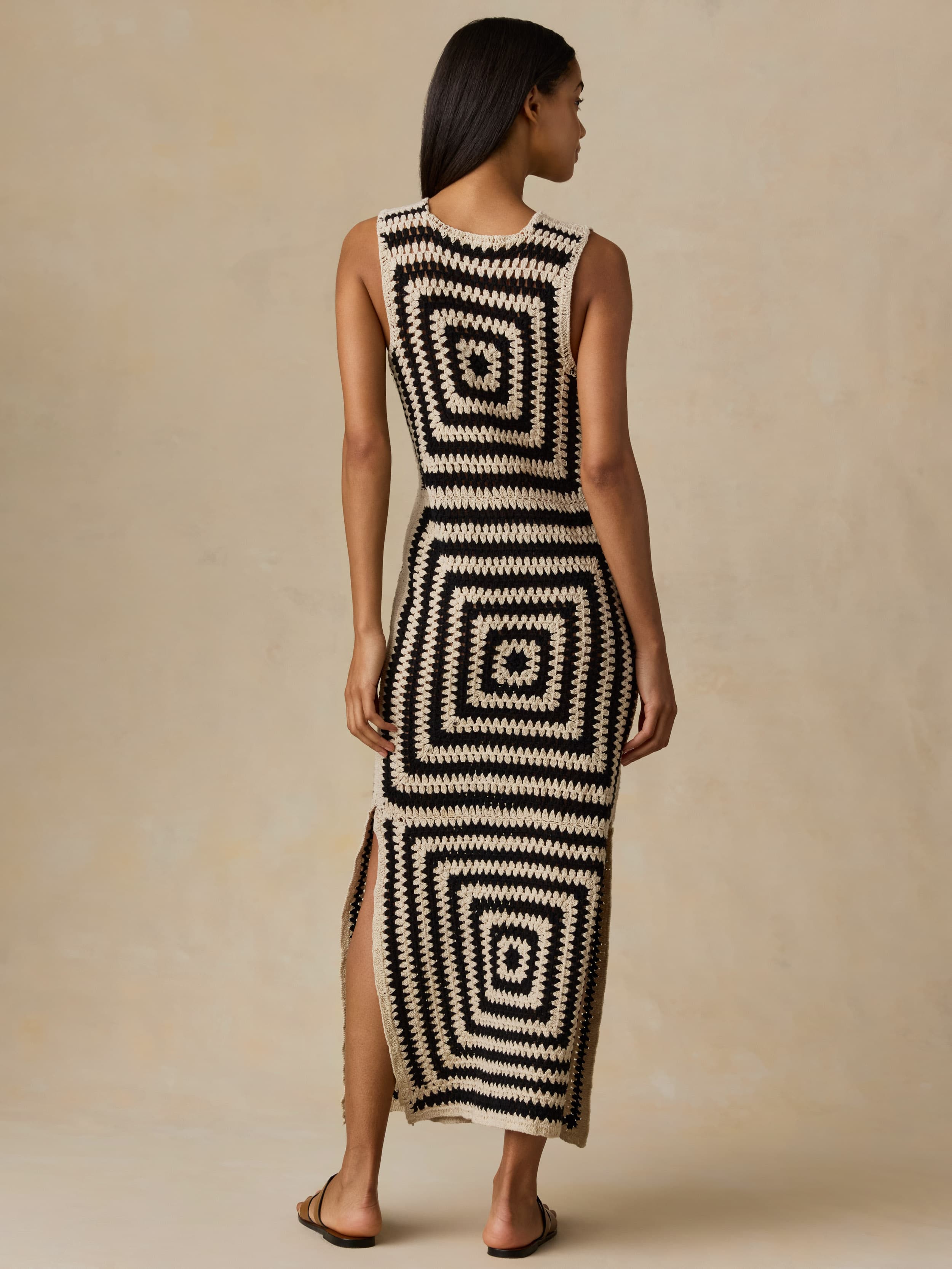 Woman wearing a black and white patterned dress against a beige background