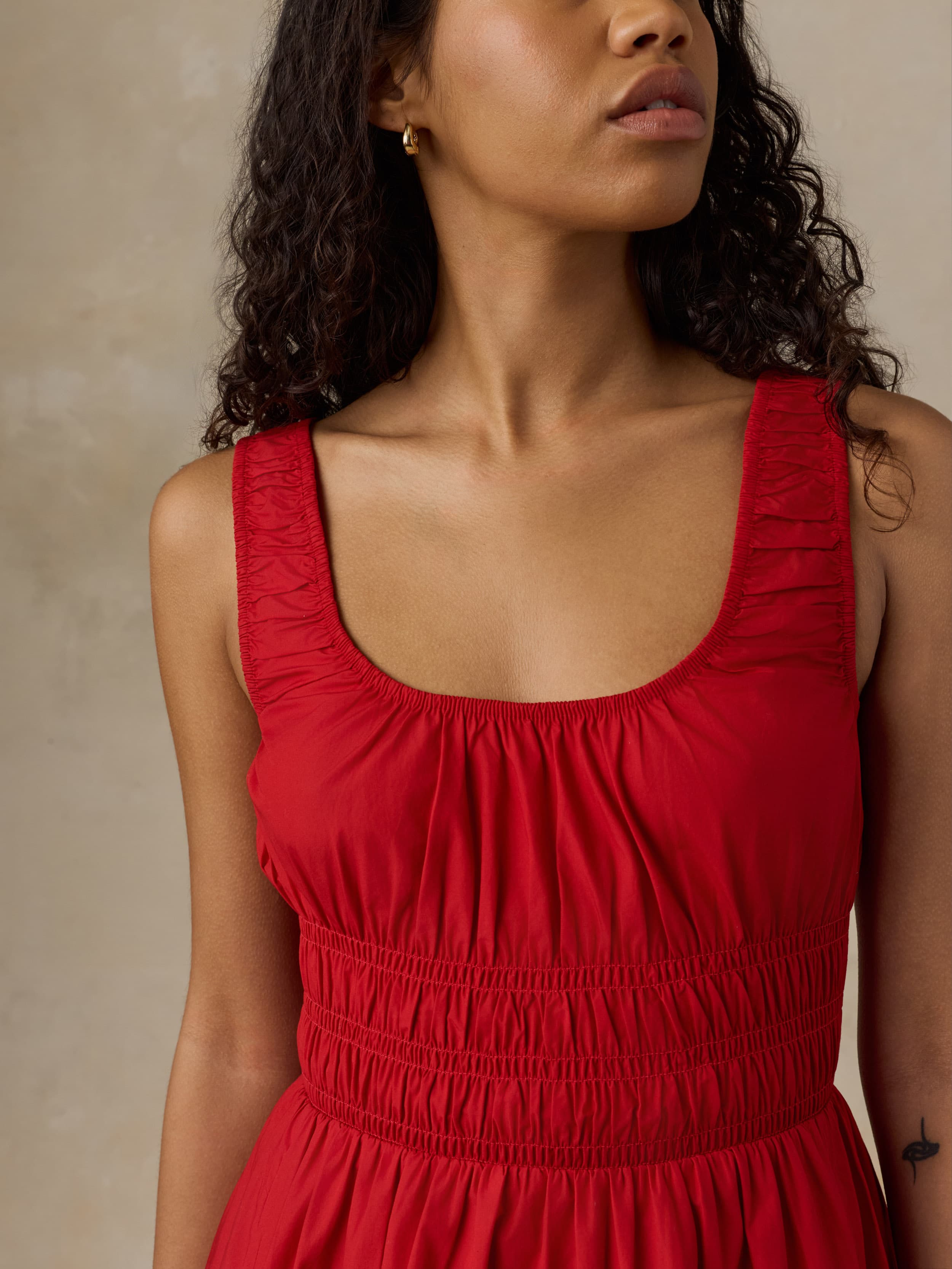 Woman wearing a red dress against a neutral background