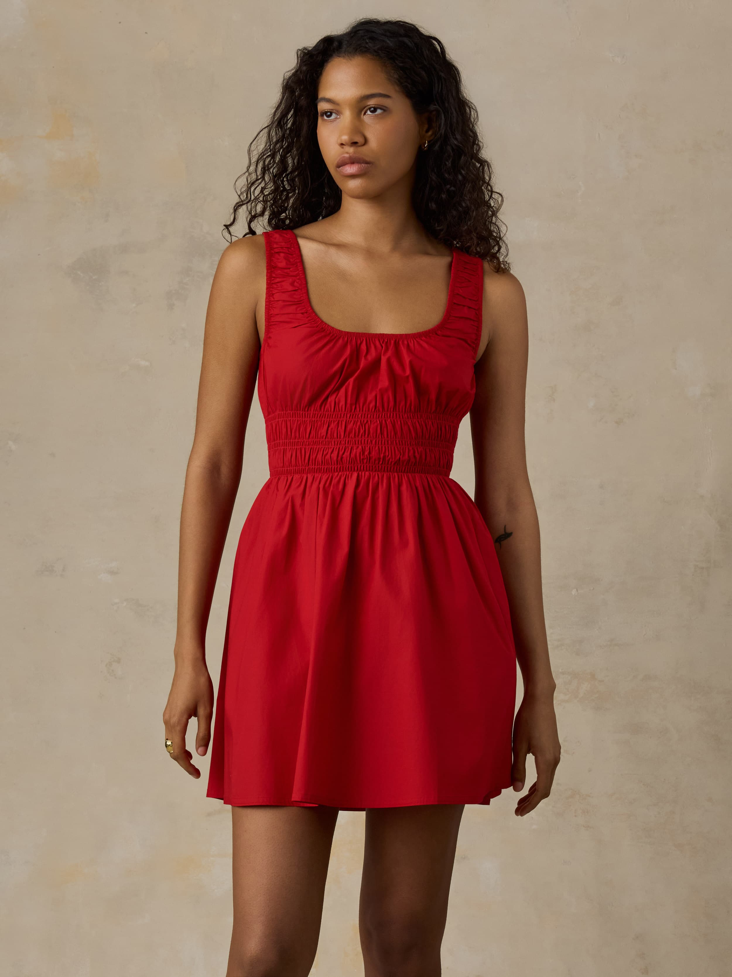 Woman wearing a red dress against a beige background