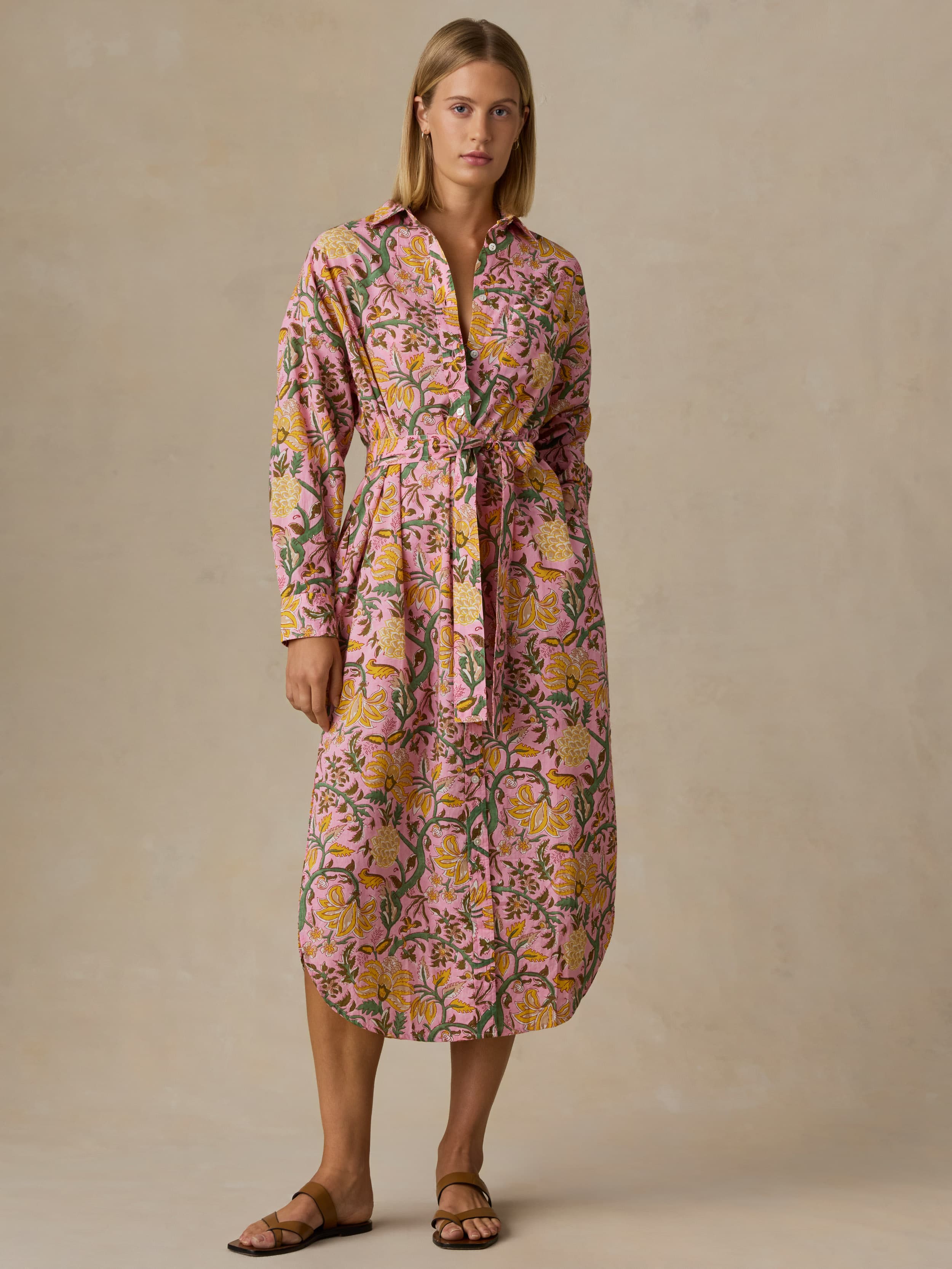 Woman wearing a floral dress against a beige background