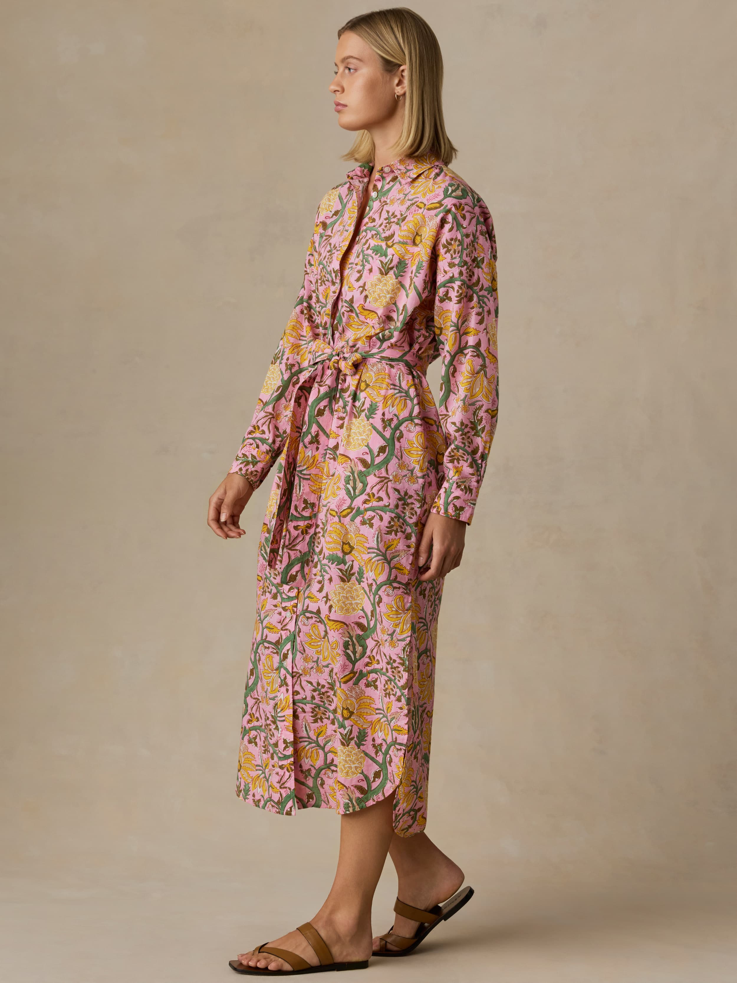 Woman wearing a floral dress against a beige background