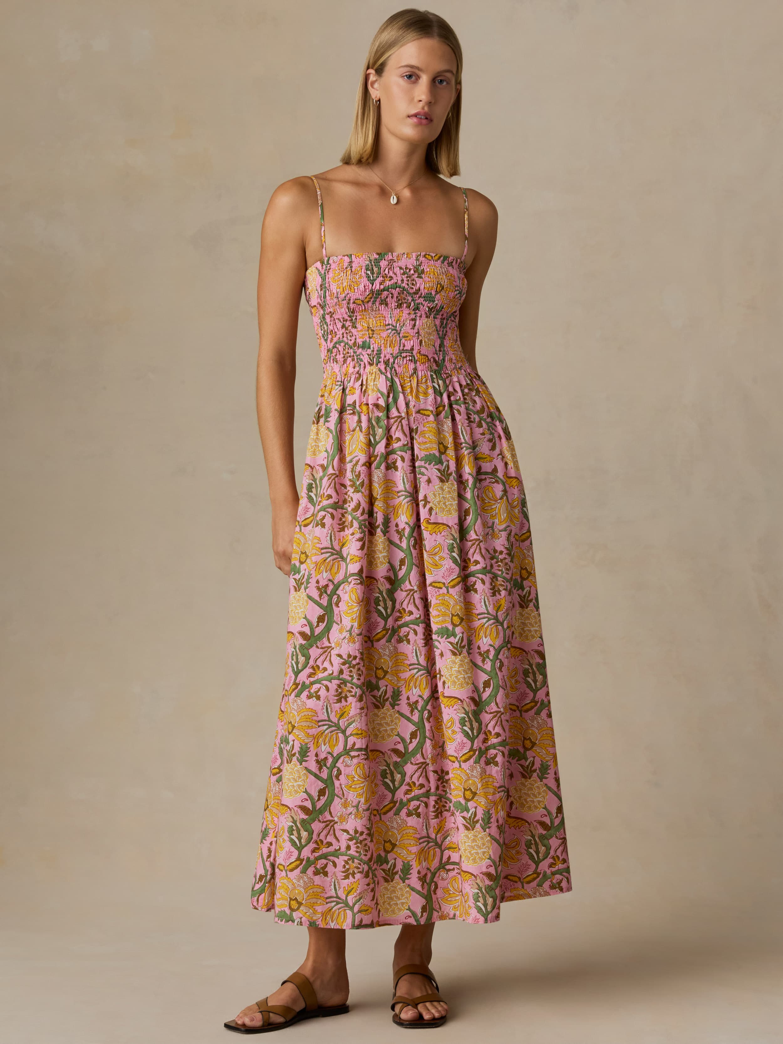 Woman wearing a floral dress against a beige background