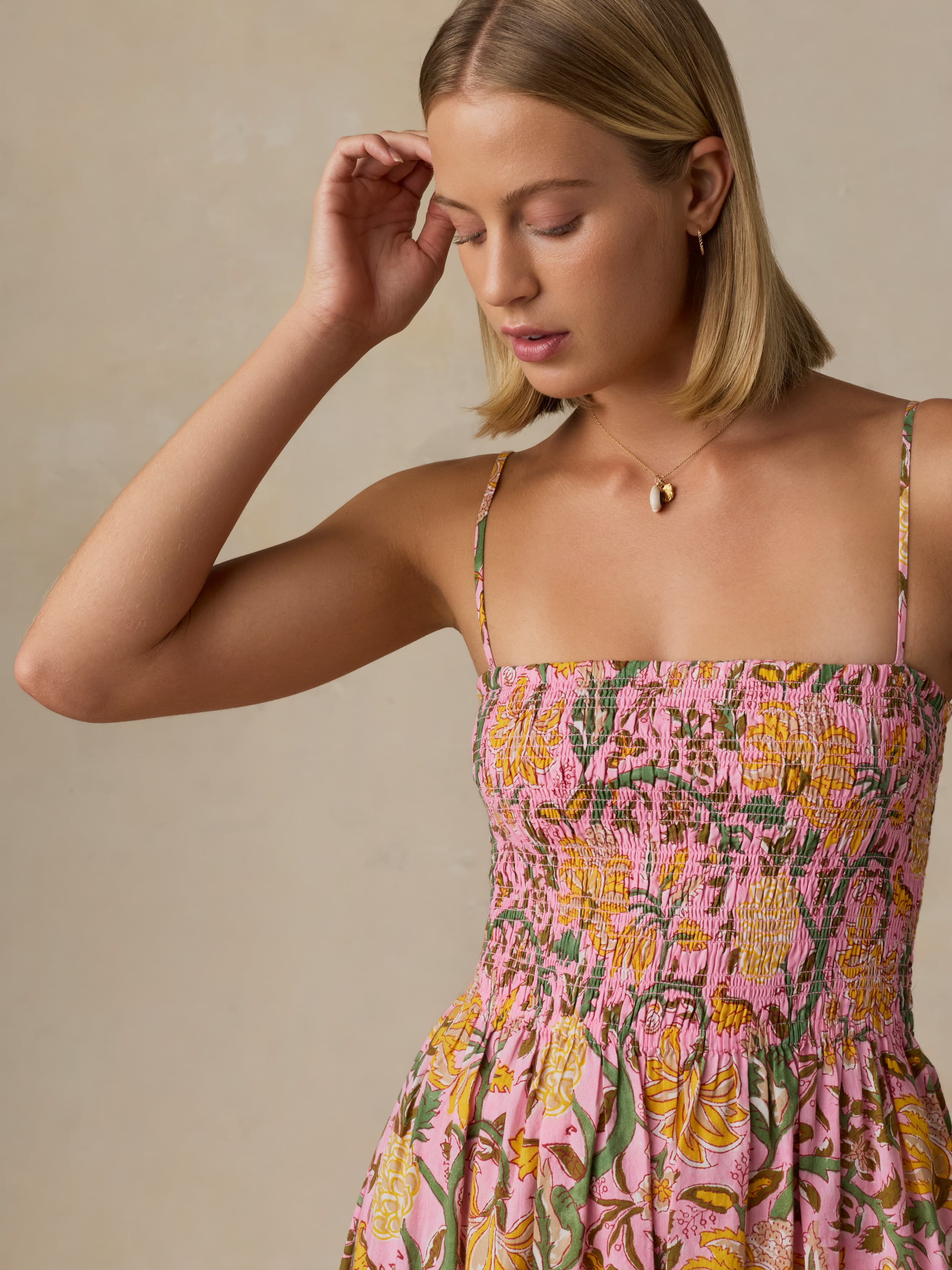 Woman wearing a floral dress with a neutral background