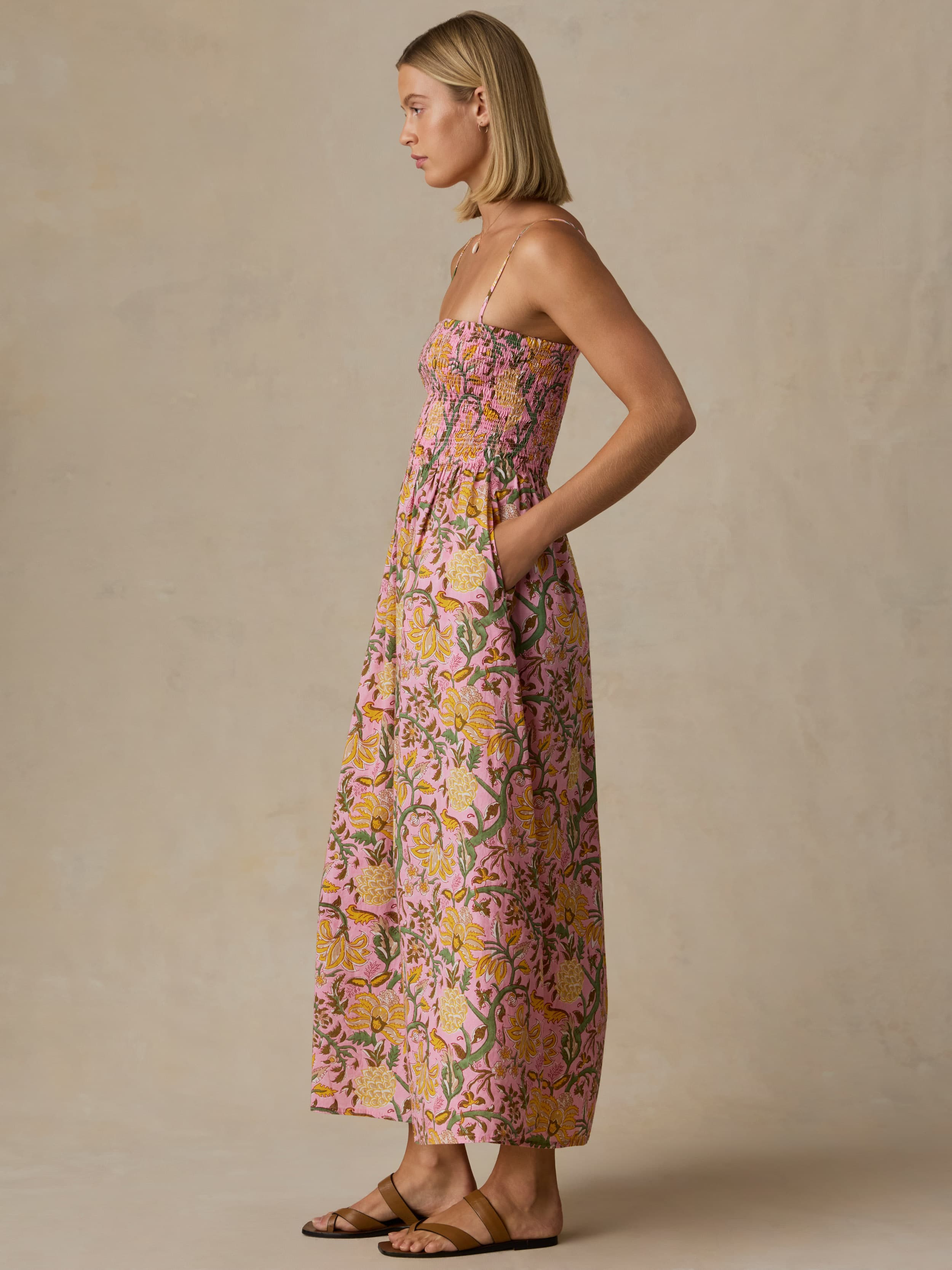 Woman wearing a floral dress against a beige background