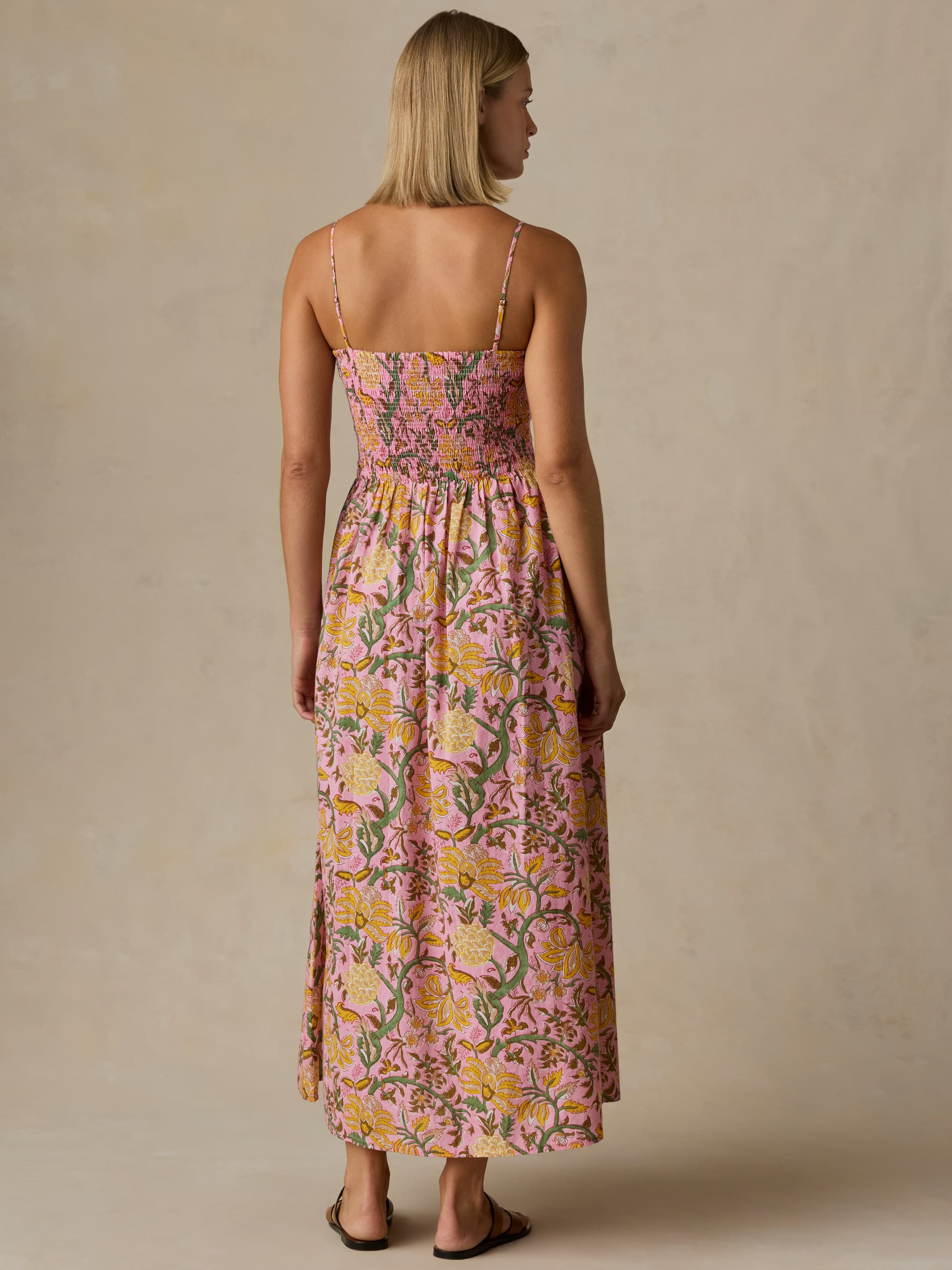 Woman wearing a floral dress against a beige background