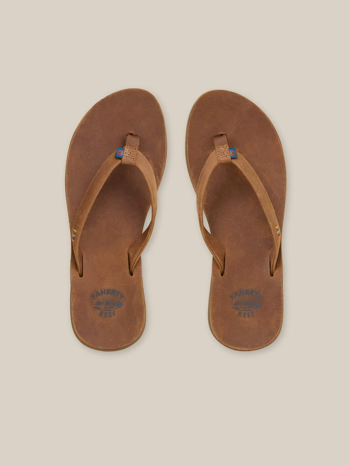 Pair of brown sandals on a beige background, image 1 of 3