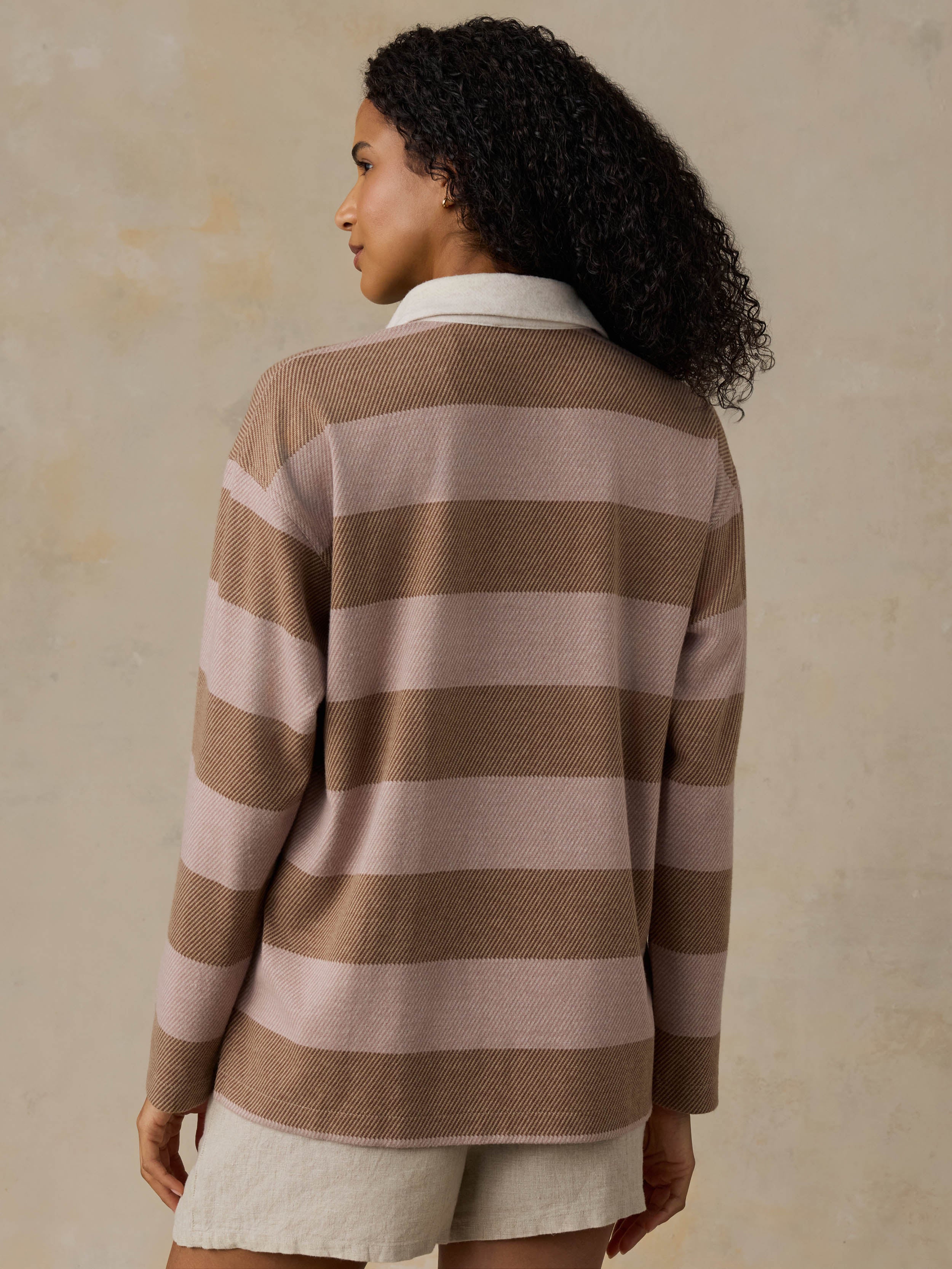 Woman wearing a brown and beige striped shirt against a beige background