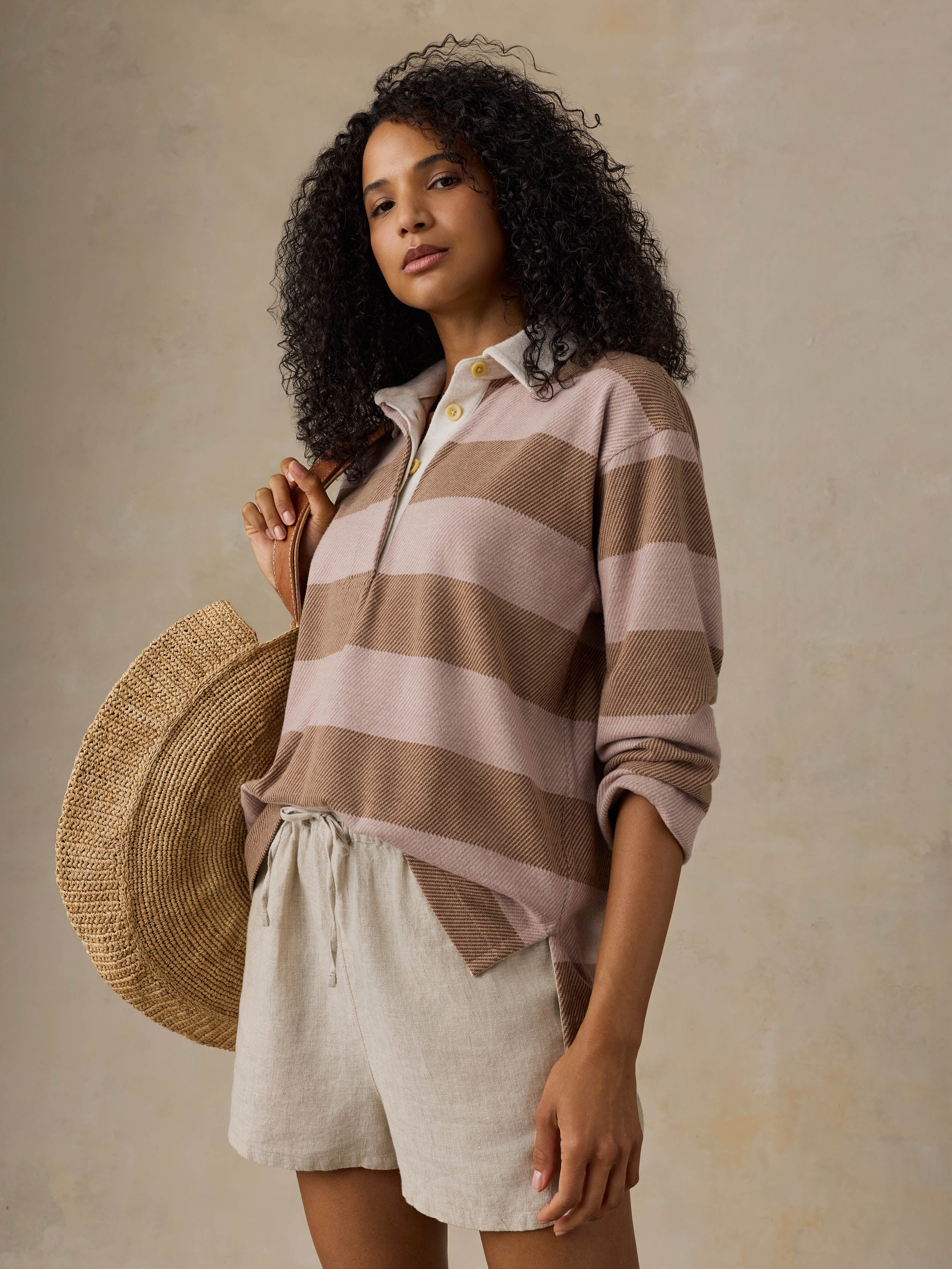 Woman wearing a brown and beige striped shirt against a beige background