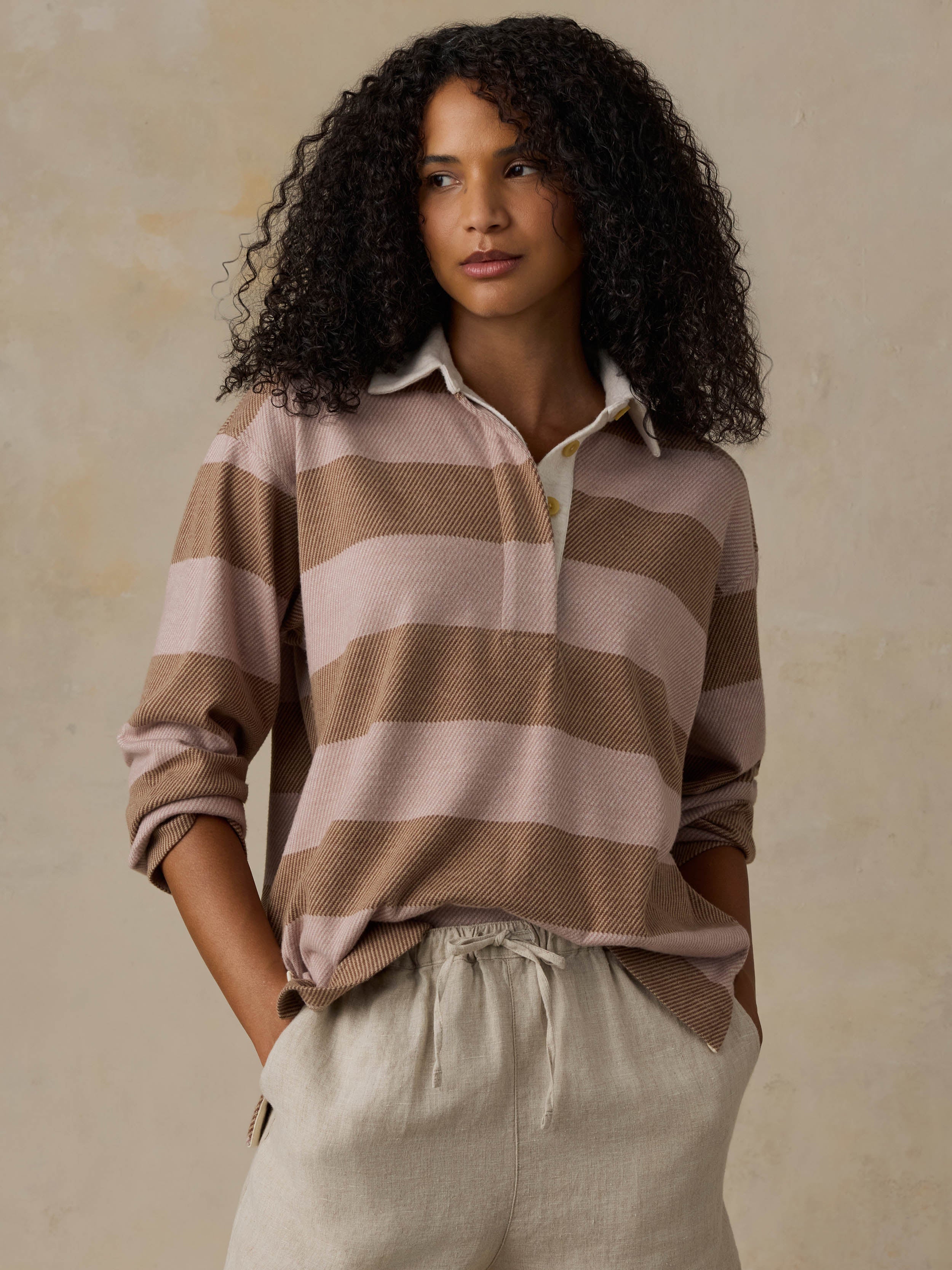 Woman wearing a brown and beige striped shirt against a beige background