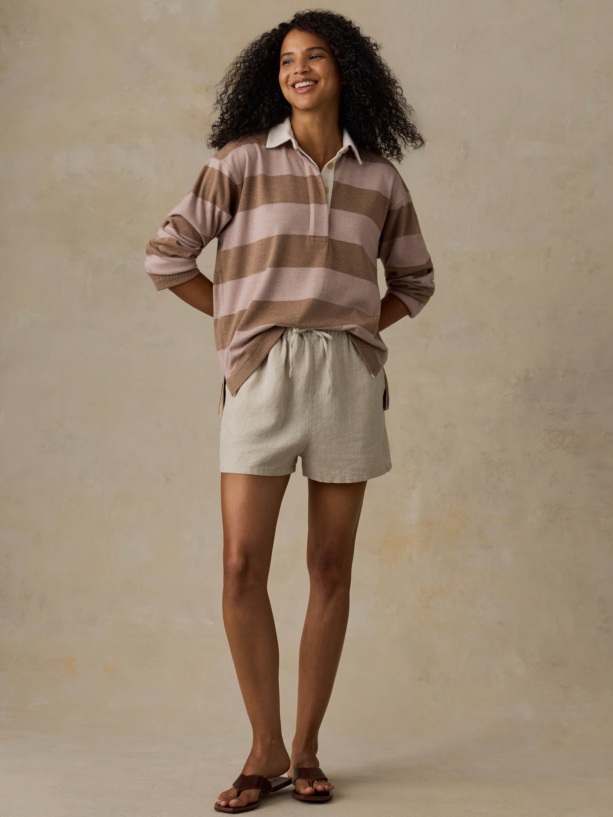 Woman wearing a brown and beige striped shirt against a beige background