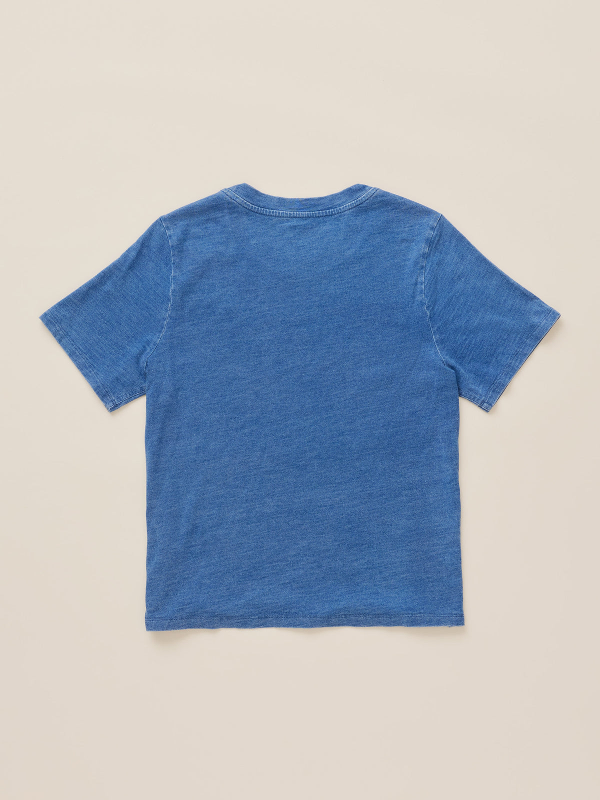 A blue short-sleeve crewneck t-shirt shown from the back, laid flat on a light beige background., image 8 of 8