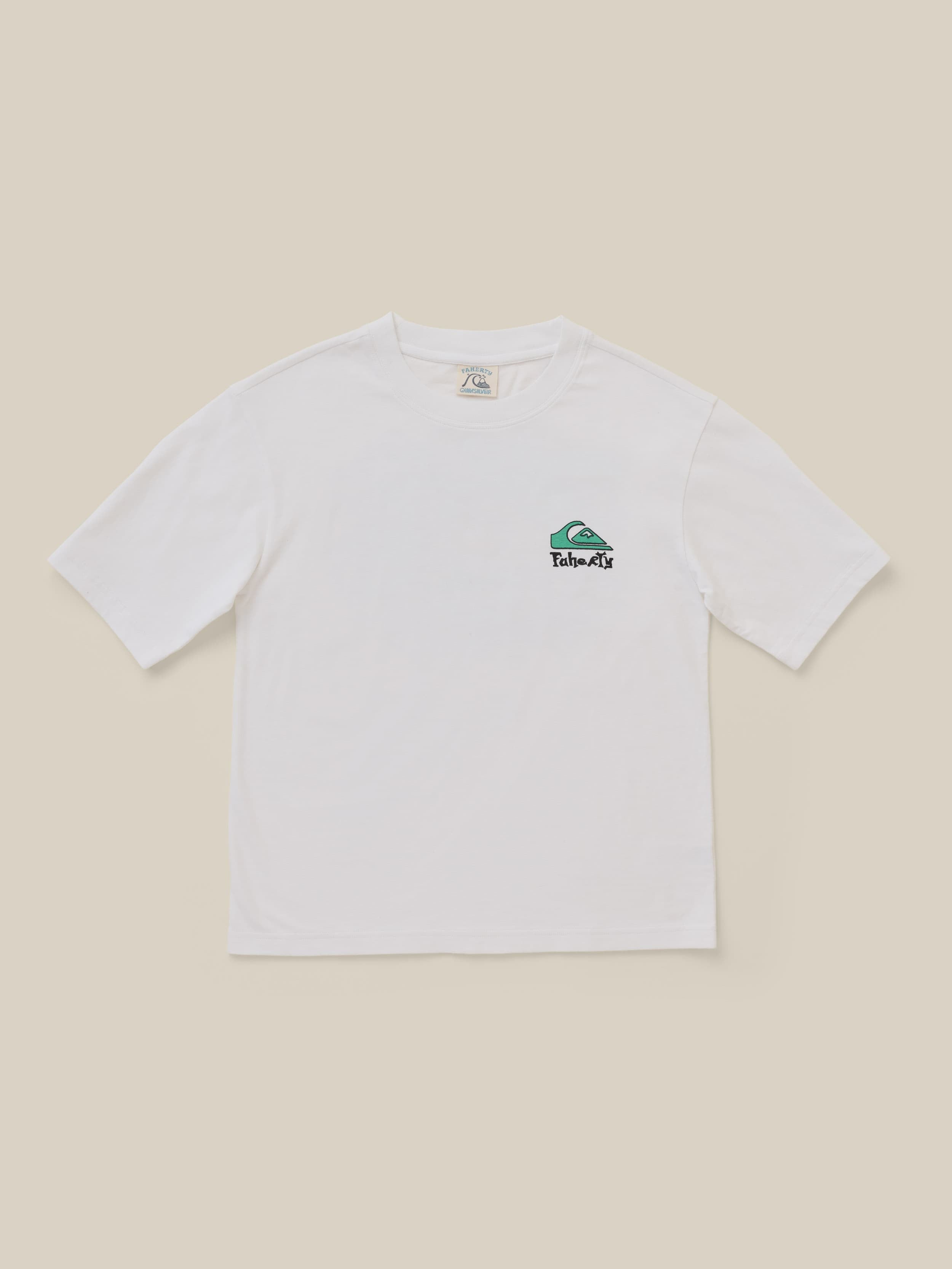 White t-shirt with Faherty x Quiksilver graphic at the left chest against a beige background