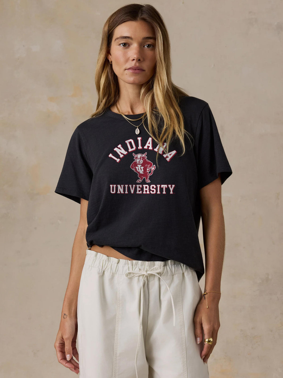 A woman wearing a black Indiana tee and white pants, image 1 of 1