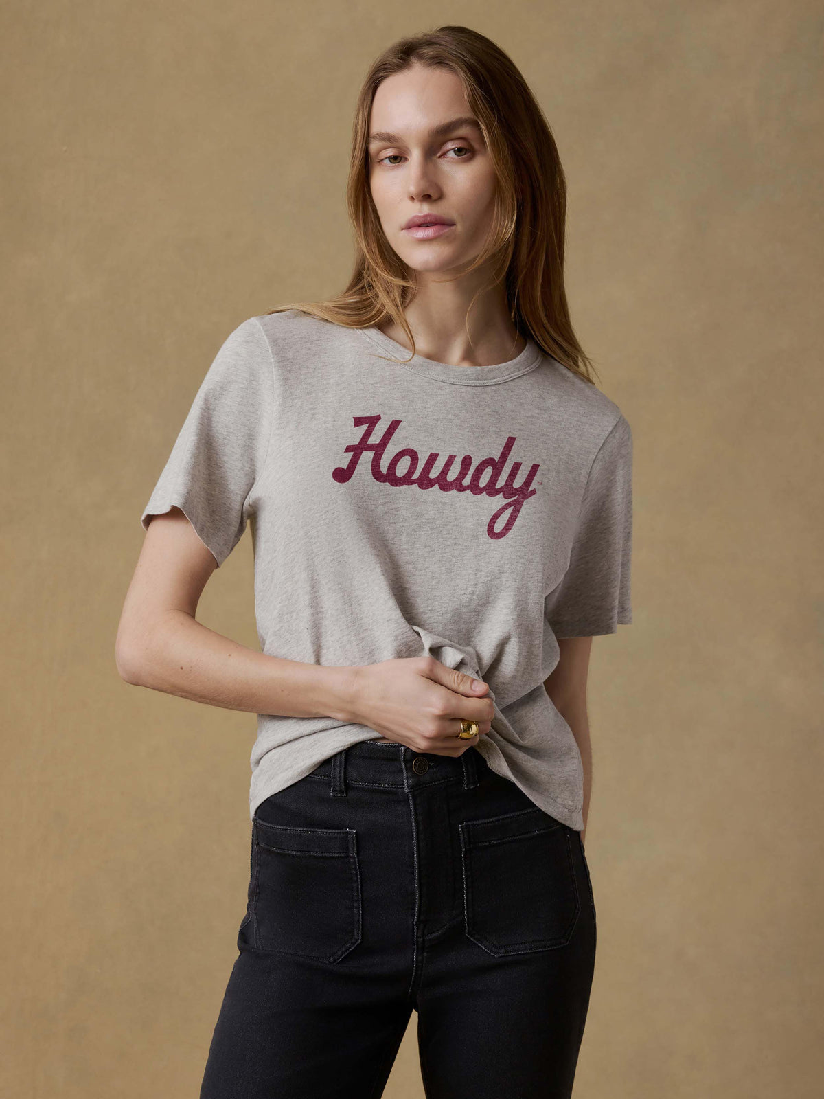 A woman wearing a grey Texas A&M tee and black jeans, image 1 of 1
