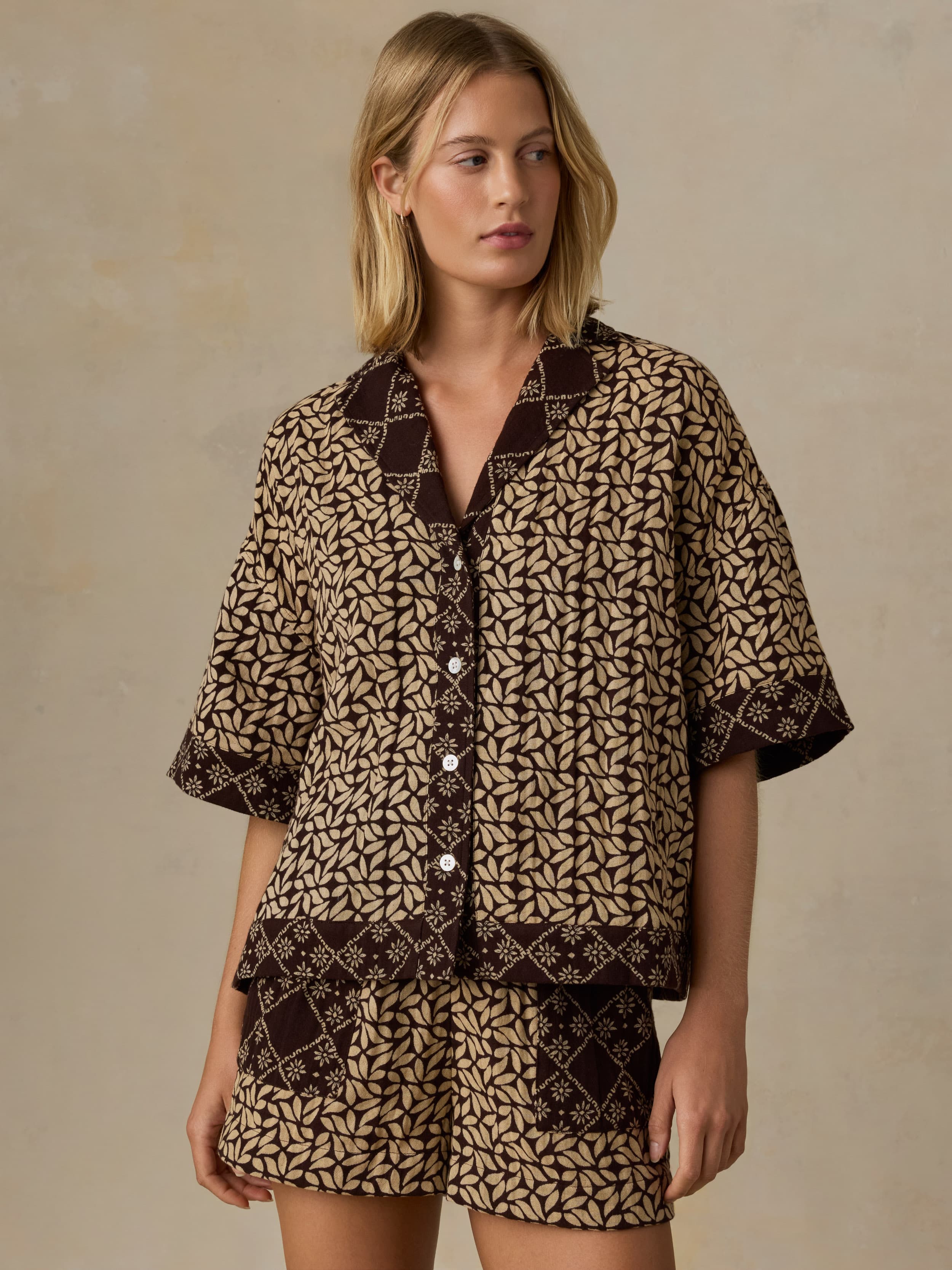 Woman wearing a patterned outfit on a beige background