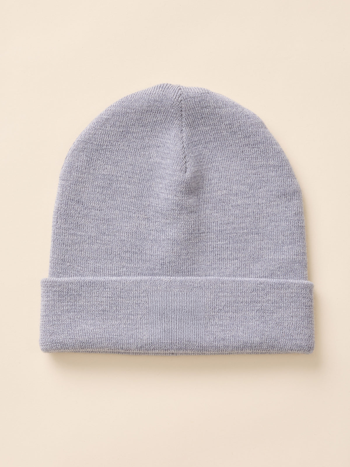 A light gray knit beanie hat with a folded cuff, shown flat against a solid beige background., image 3 of 3