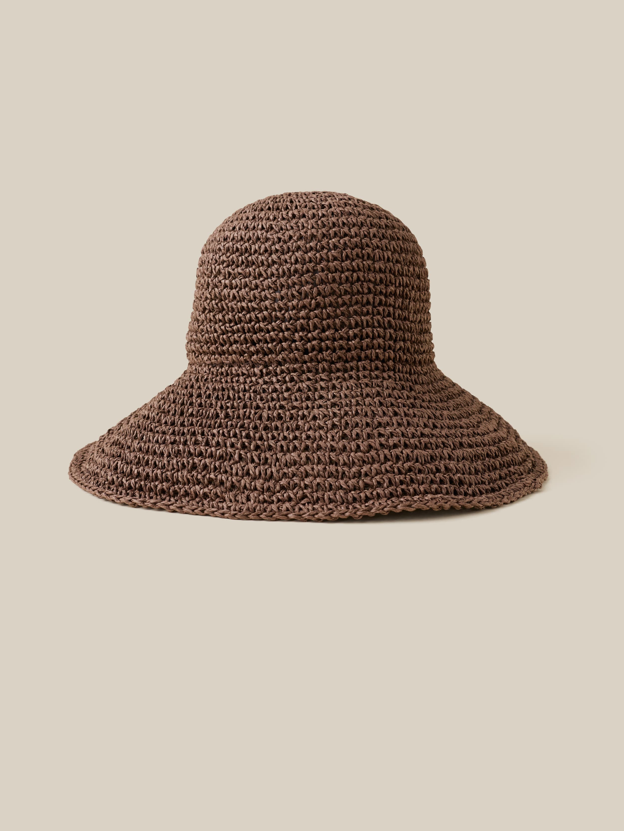 Brown knitted bucket hat on a beige background