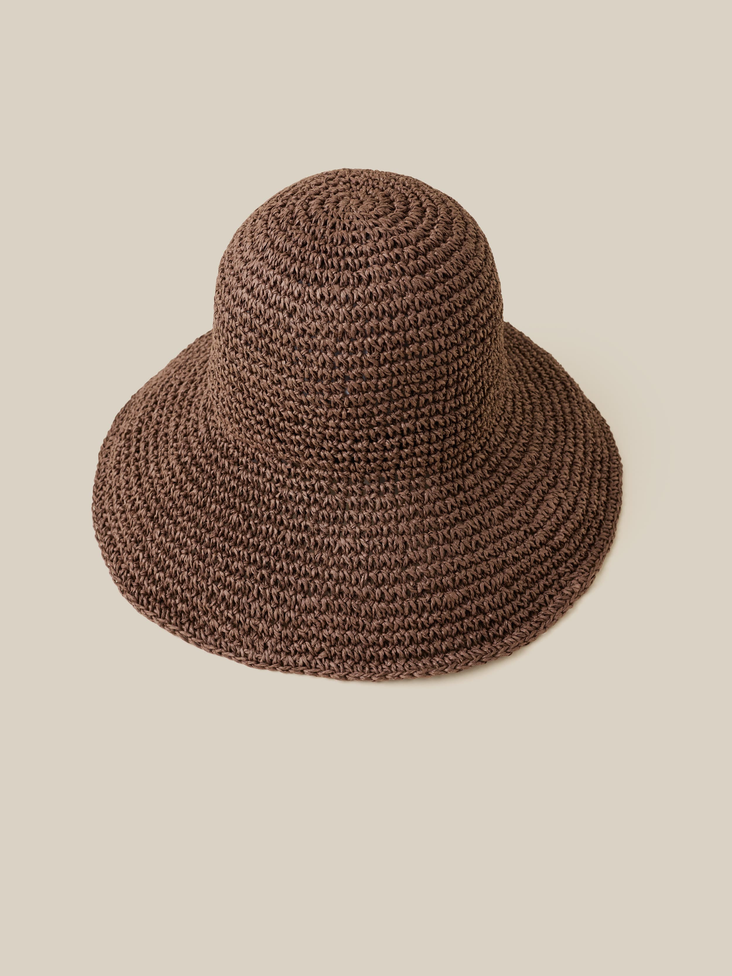 Brown woven hat on a beige background