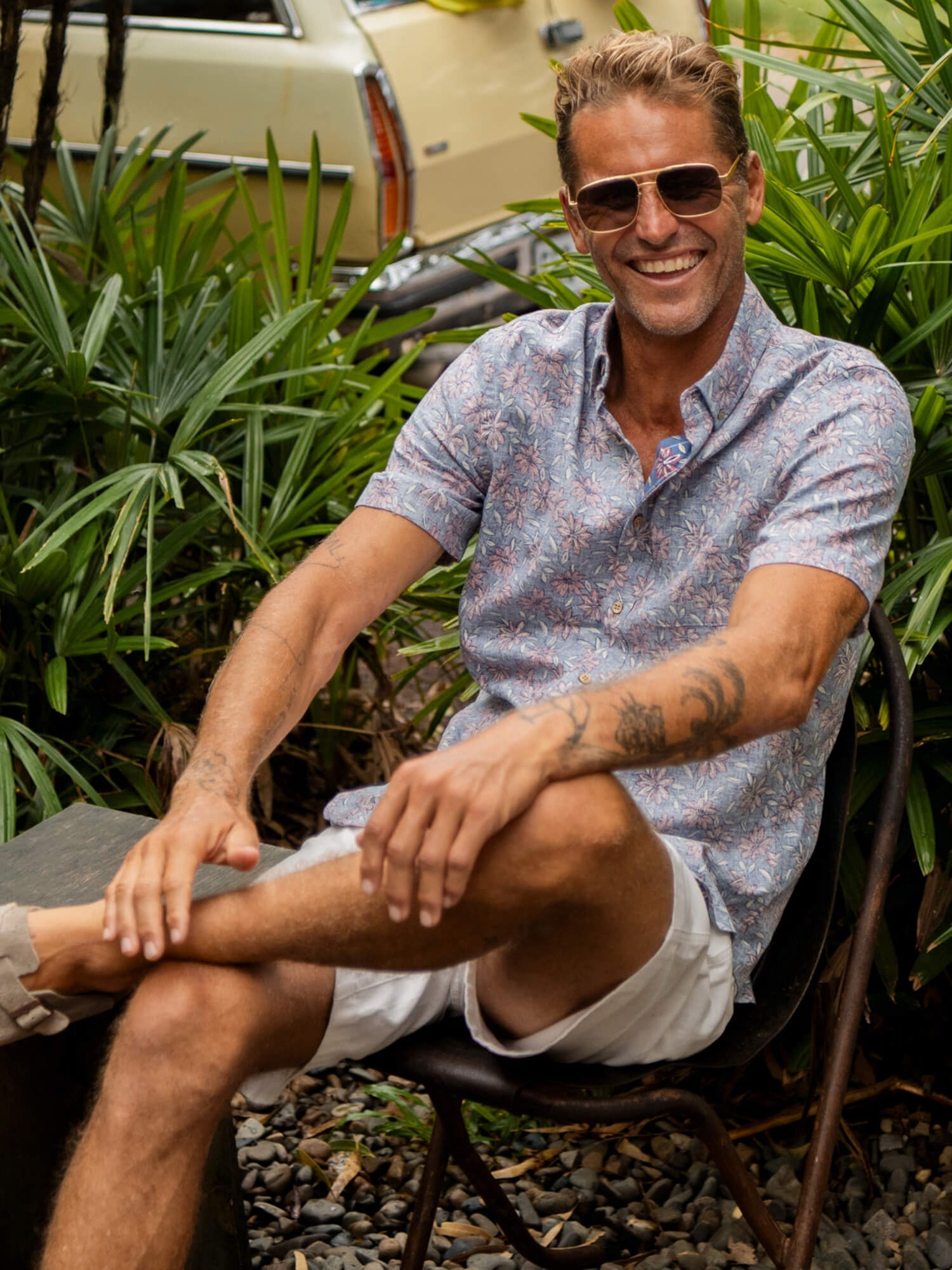 Man sitting on a chair wearing a floral printed shirt