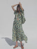 Video of a woman wearing a tropical print shirt and matching skirt against a white background
