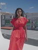 Video of a woman wearing a poppy red dress on a rooftop