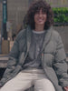 Video of a woman wearing a green jacket, striped shirt, and white jeans