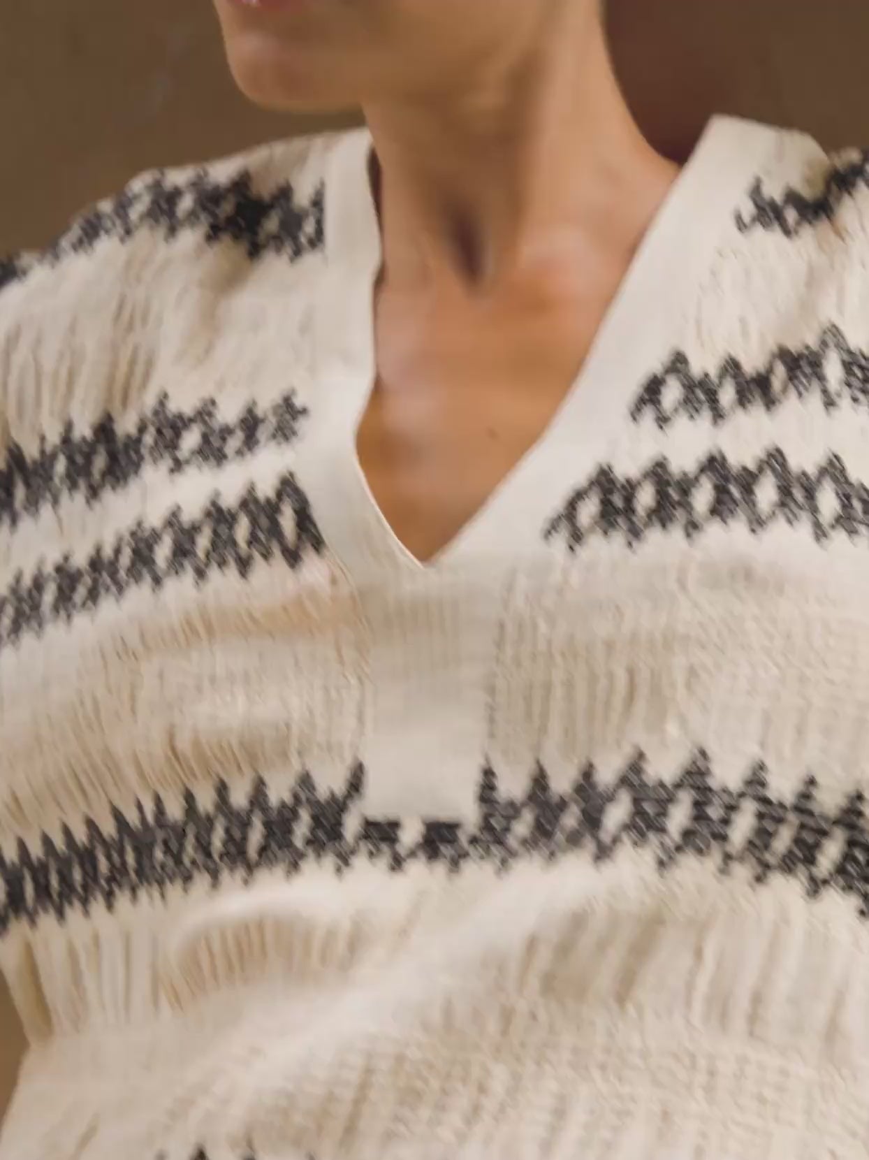 Video of a woman wearing a patterned dress sitting in a leather chair