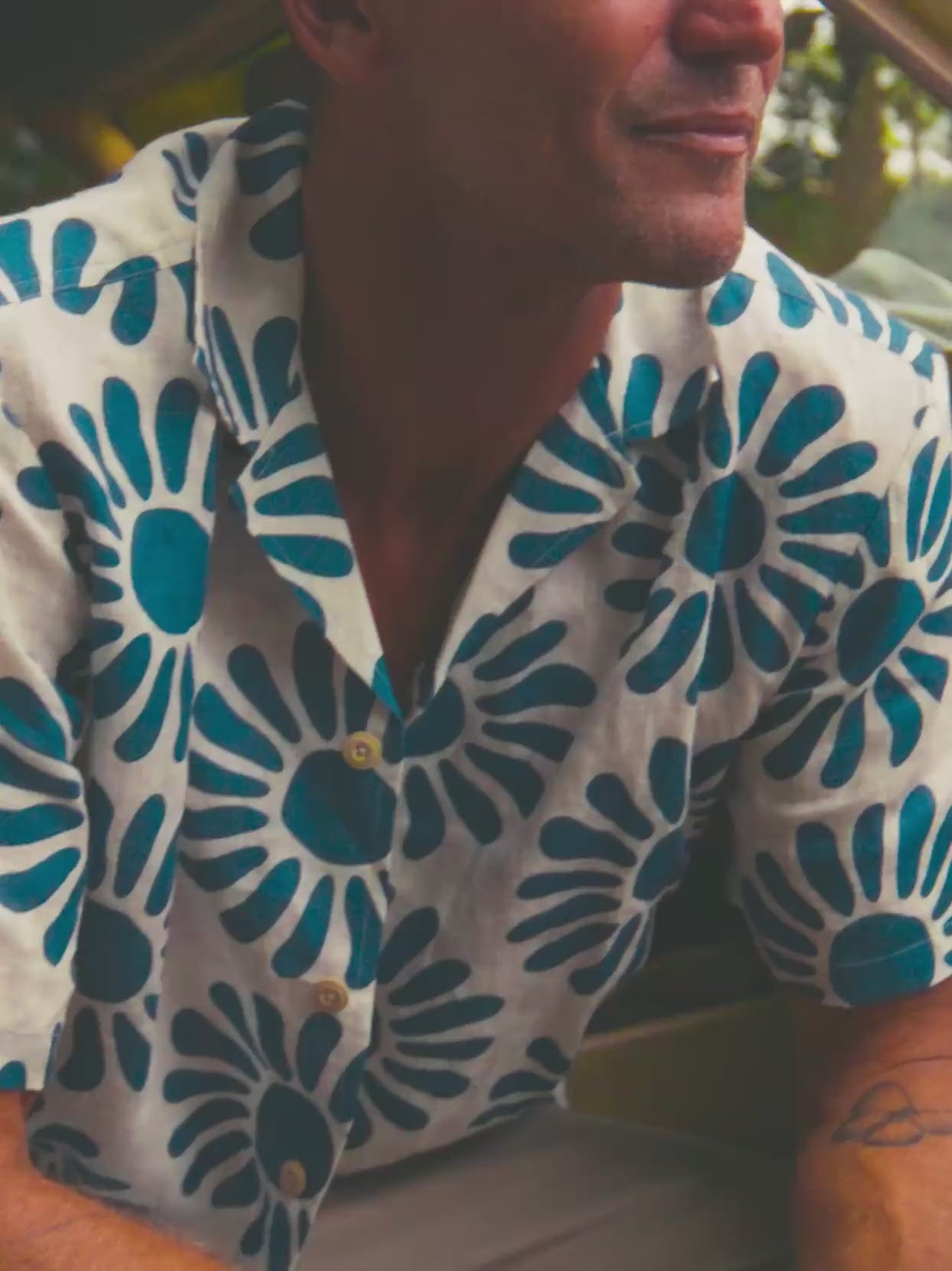 Video of a man wearing a printed shirt and pants at the beach