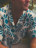 Video of a man wearing a printed shirt and pants at the beach