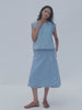 Video of a woman wearing a denim shell top and matching wrap skirt against a white background