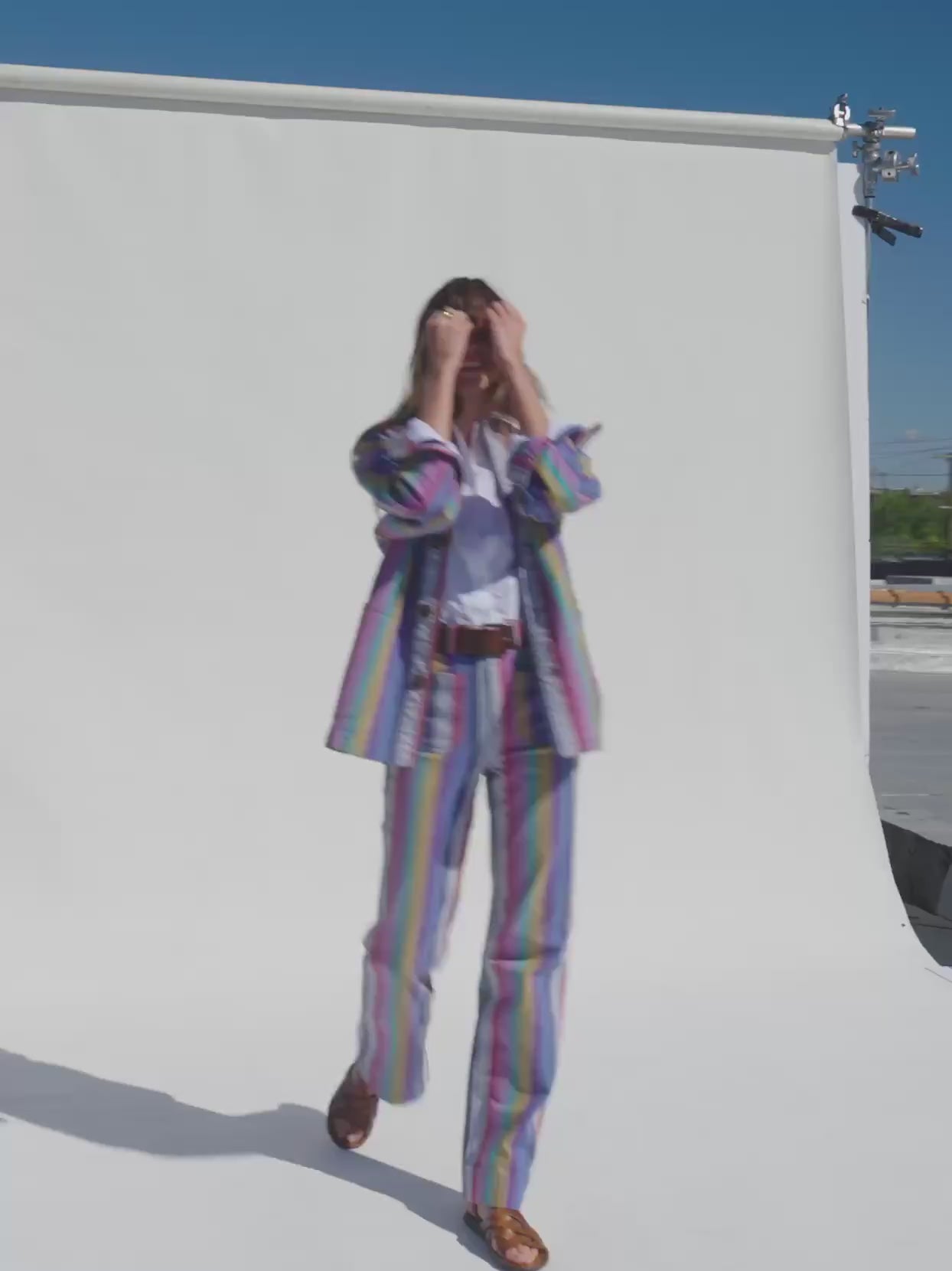 Video of a woman wearing a colorful striped matching set against a white background