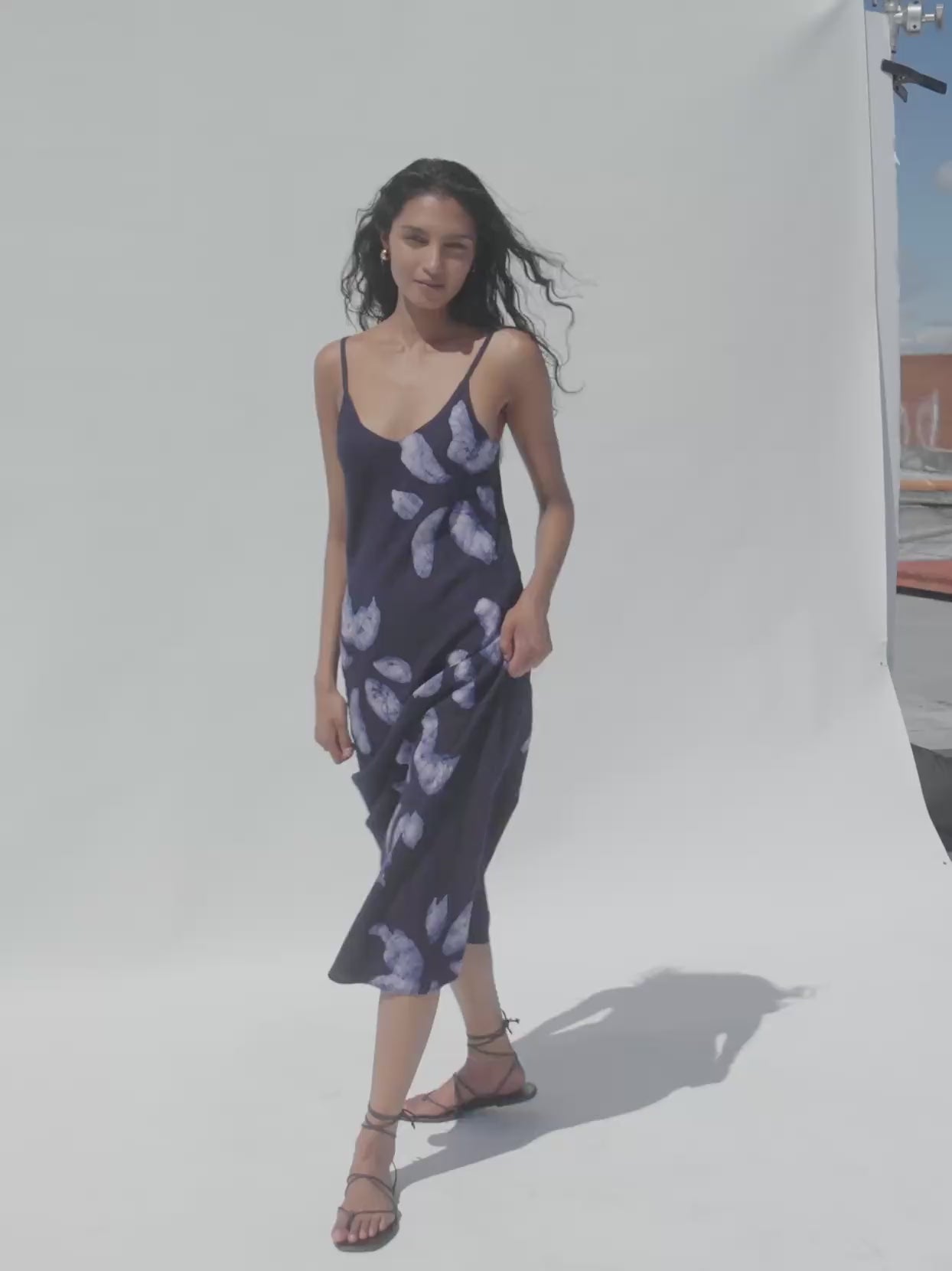 Video of a woman wearing a floral printed dress against a white background