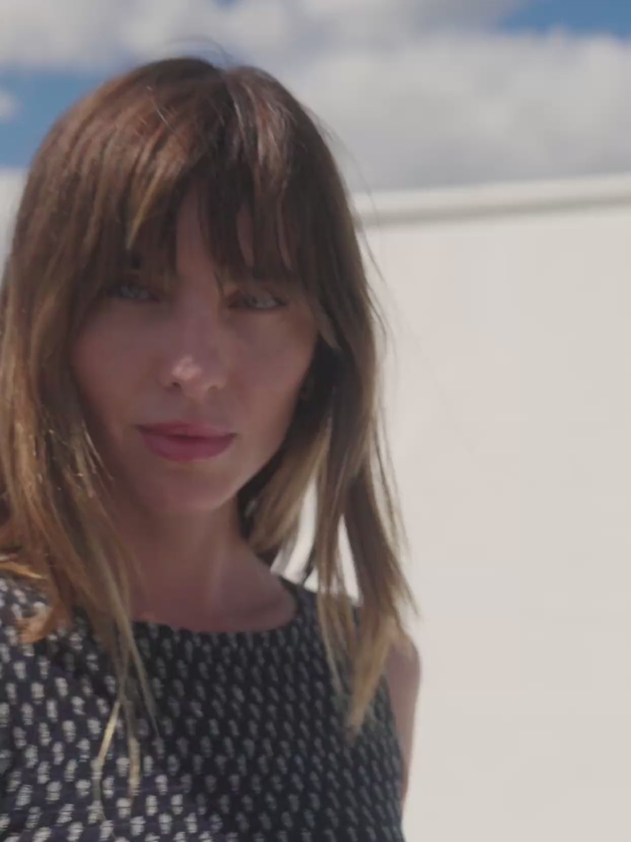 Video of a woman wearing a floral smocked peplum top and matching skirt against a white background