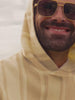 Man wearing a hoodie and swim trunks at the beach