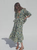 Video of a woman wearing a tropical print shirt and matching skirt against a white background