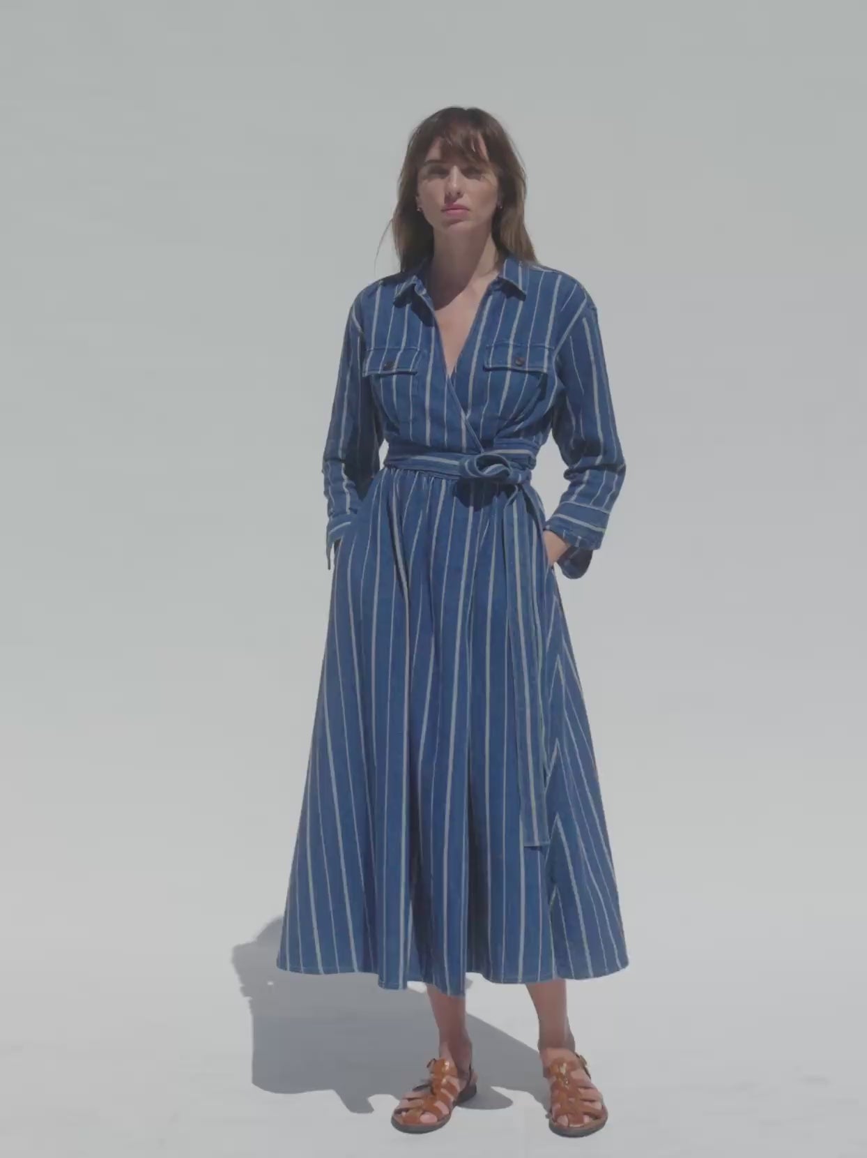 Video of a woman wearing an indigo striped wrap dress against a white background