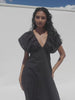 Video of a woman wearing a black dress against a white background