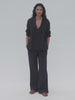 Video of a woman wearing a black gauze top and matching pants against a white background