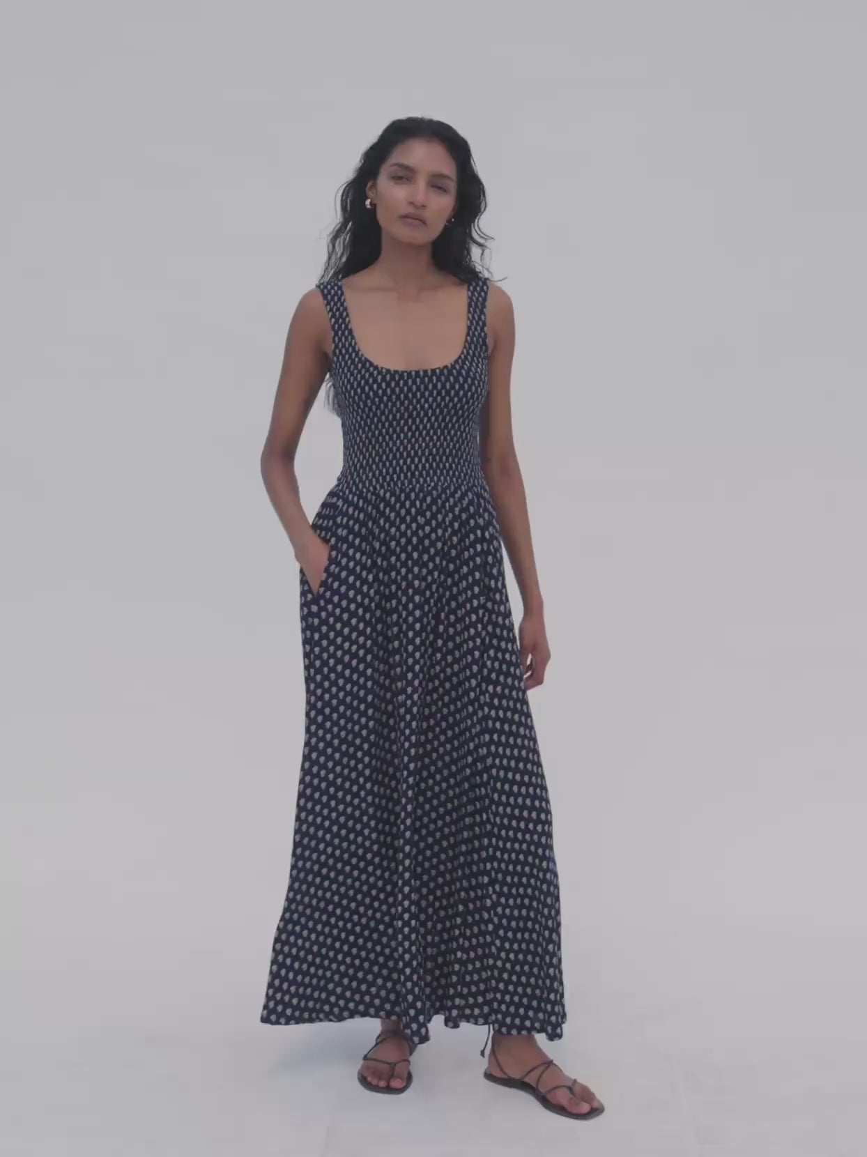 Video of a woman wearing a floral smocked dress against a white background