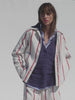 Video of a woman wearing a red striped outfit with a navy blue sweater and blue button down shirt against a white background