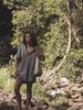 Video of a woman wearing a blue and white striped dress walking in a river.