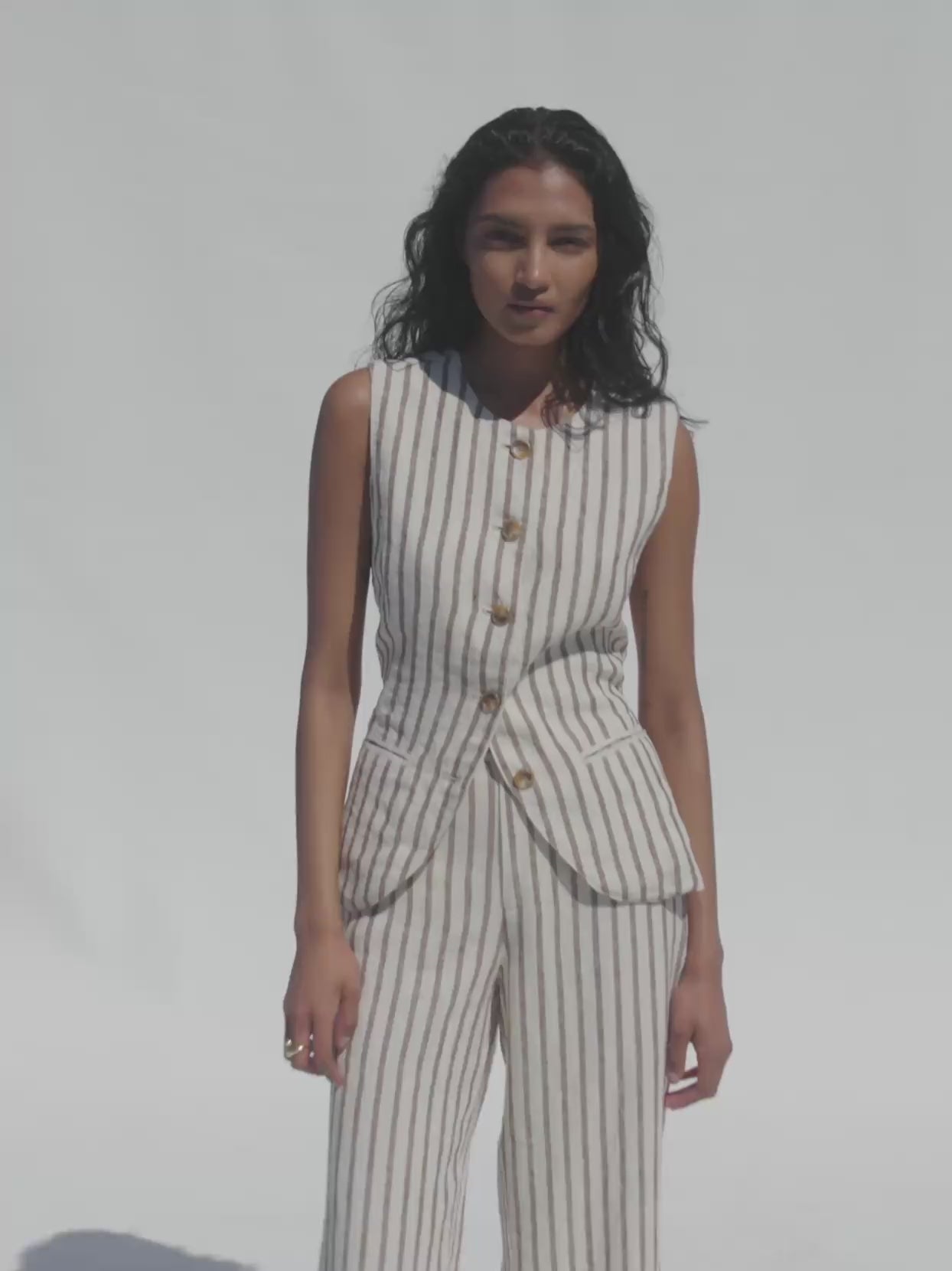 Video of a woman wearing a brown striped linen vest with matching pants